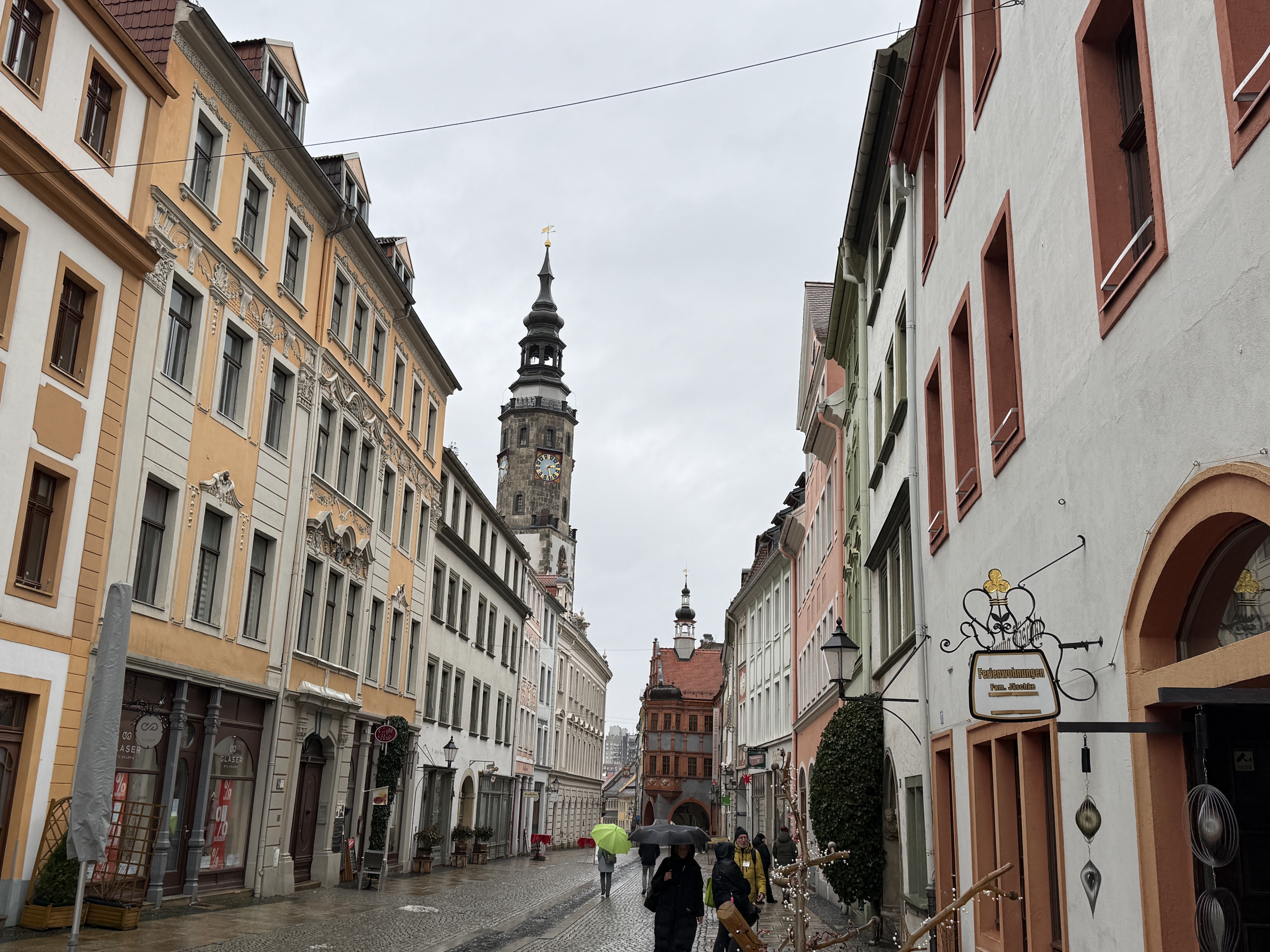 Menschen gehen eine historische europäische Straße entlang.