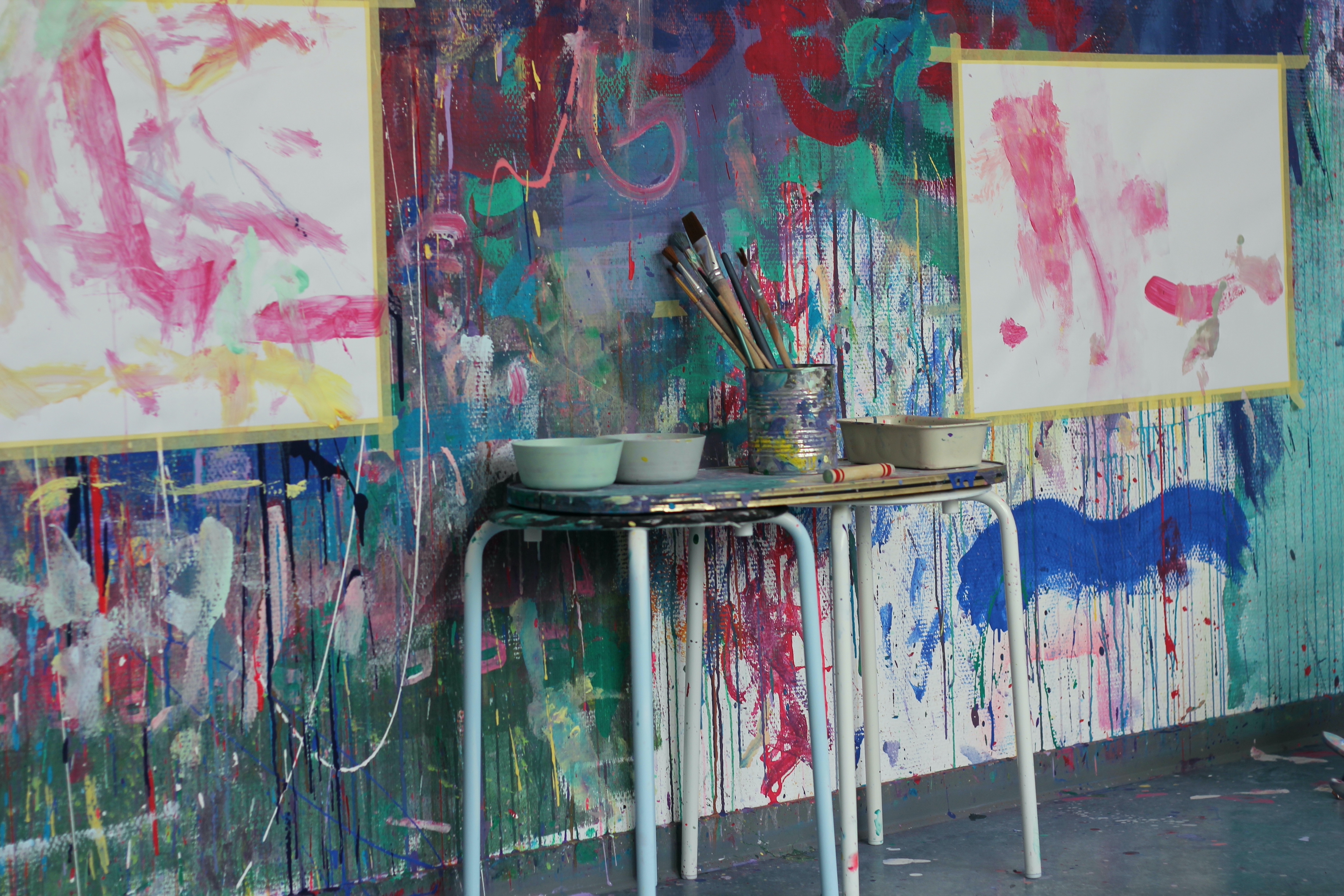 Kunstbedarf auf Tisch in buntem Studio.