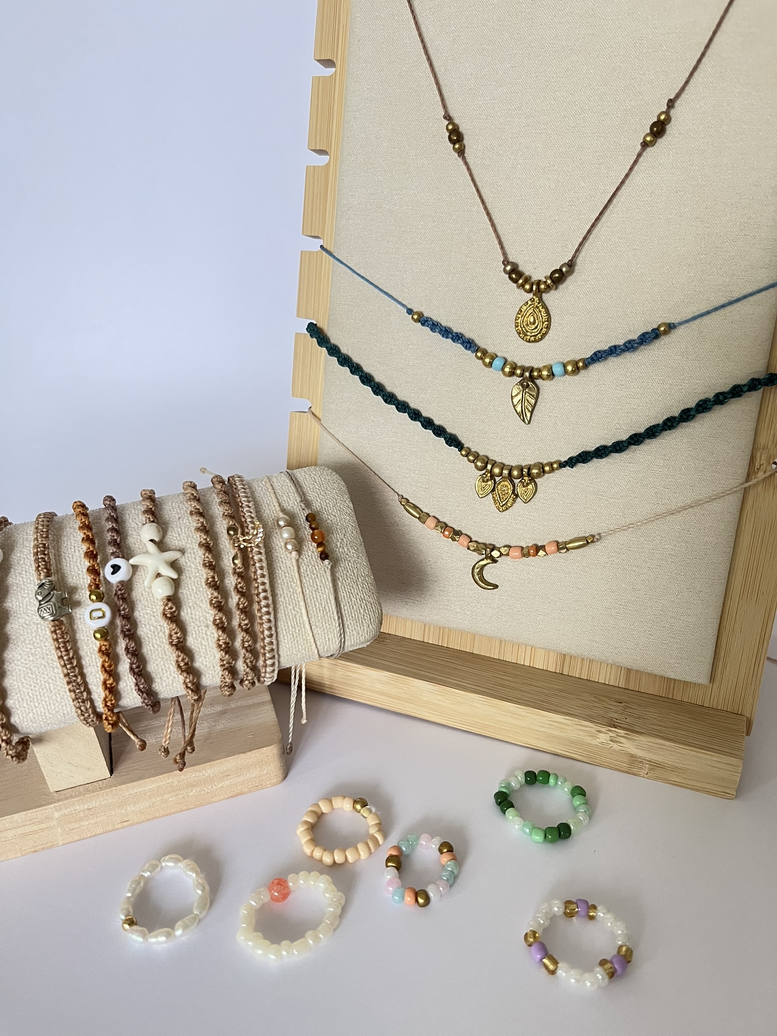Handmade jewelry displayed on wooden stands.