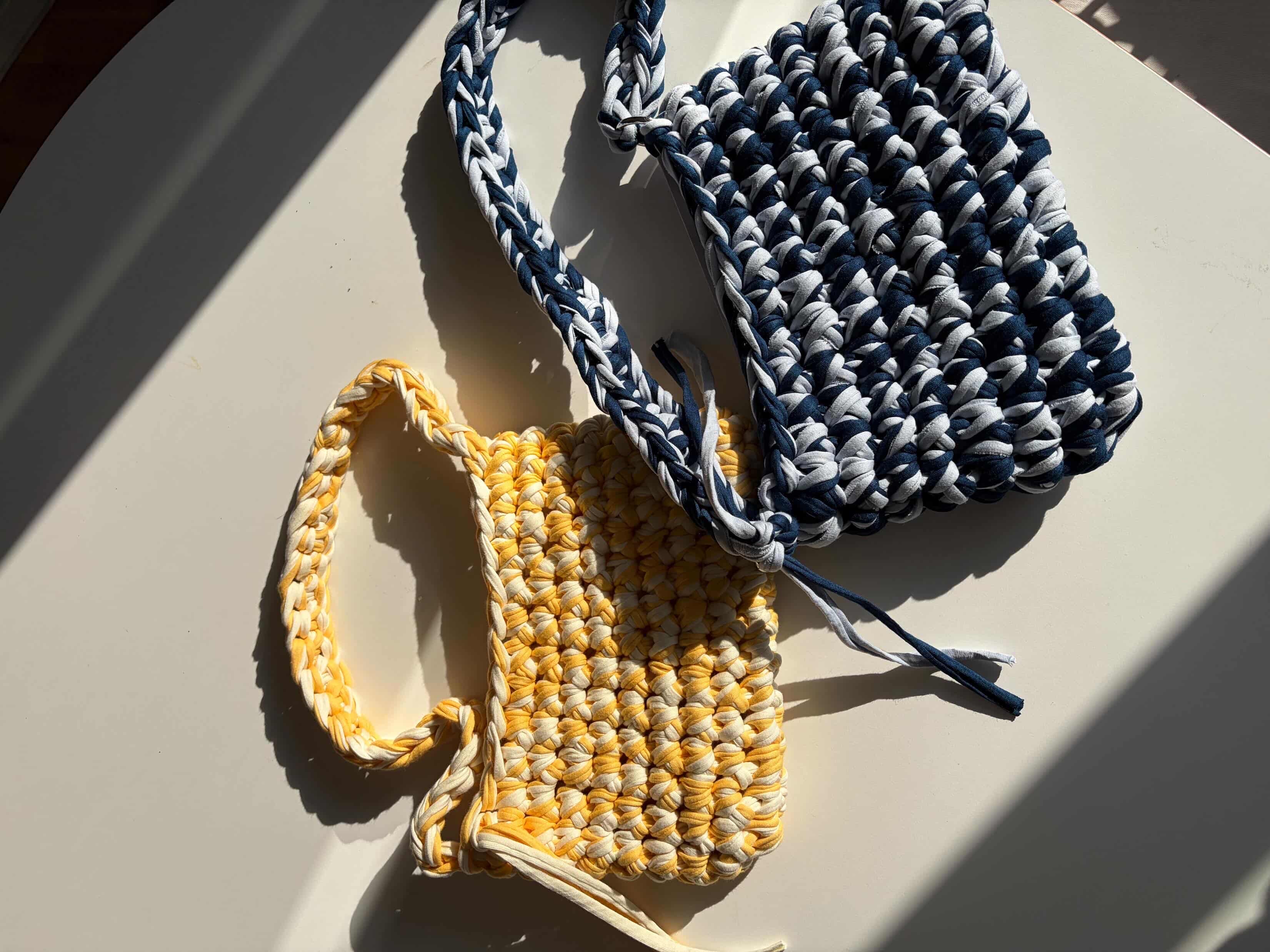 Zwei gehäkelte Taschen mit Streifenmuster.