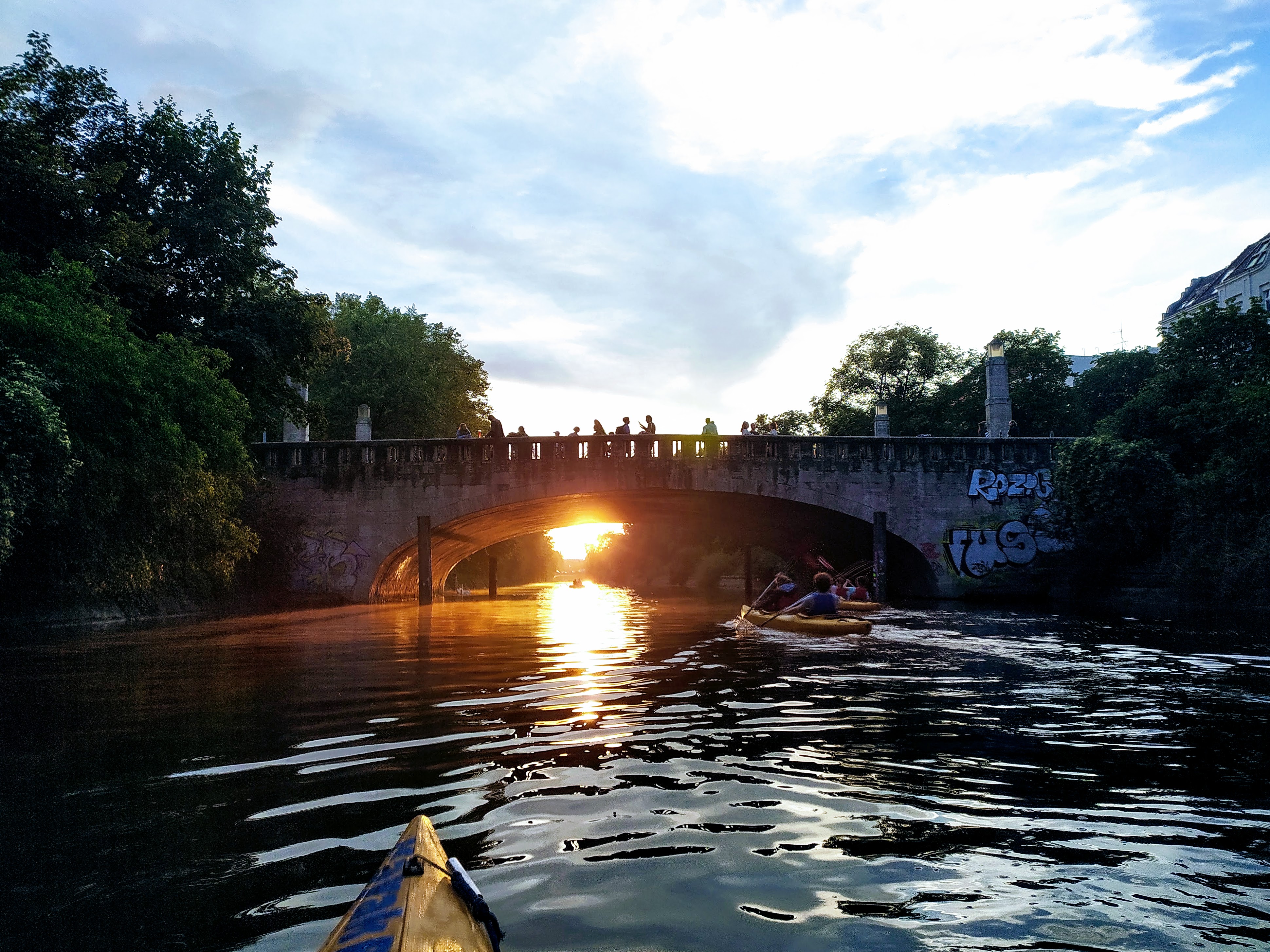 Kajak nähert sich einer sonnigen Steinbrücke.