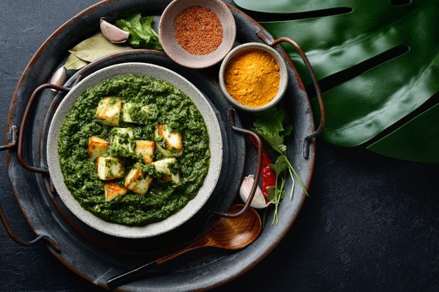 Green dish with cubes of cheese on a tray.