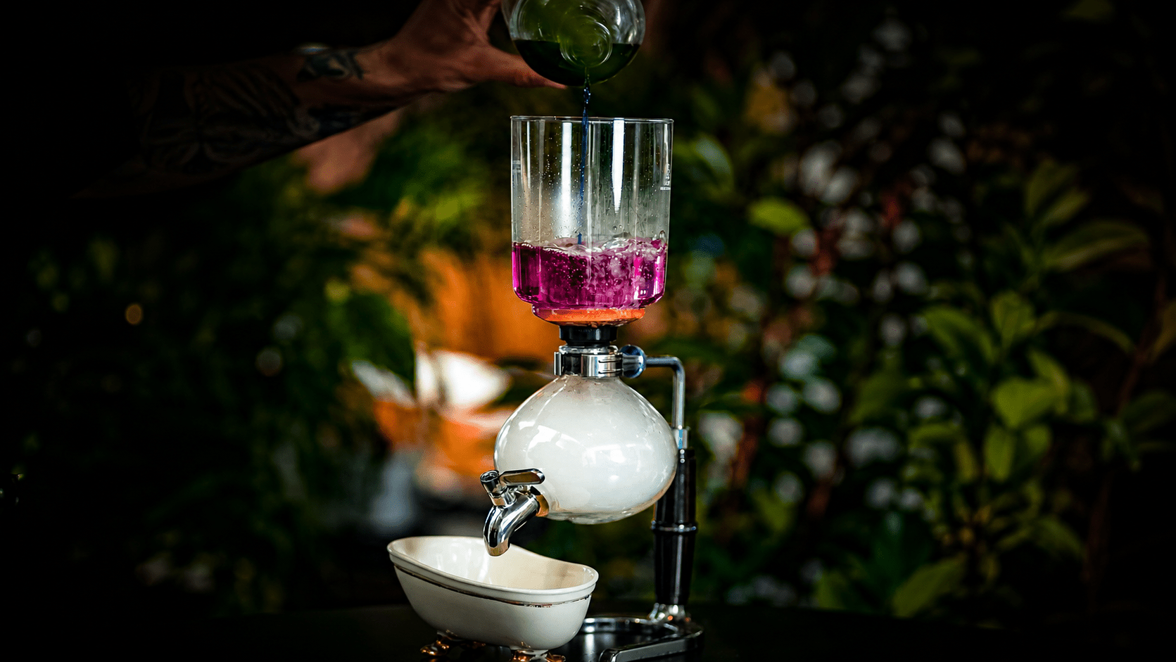 Person pouring liquid into a drink siphon.