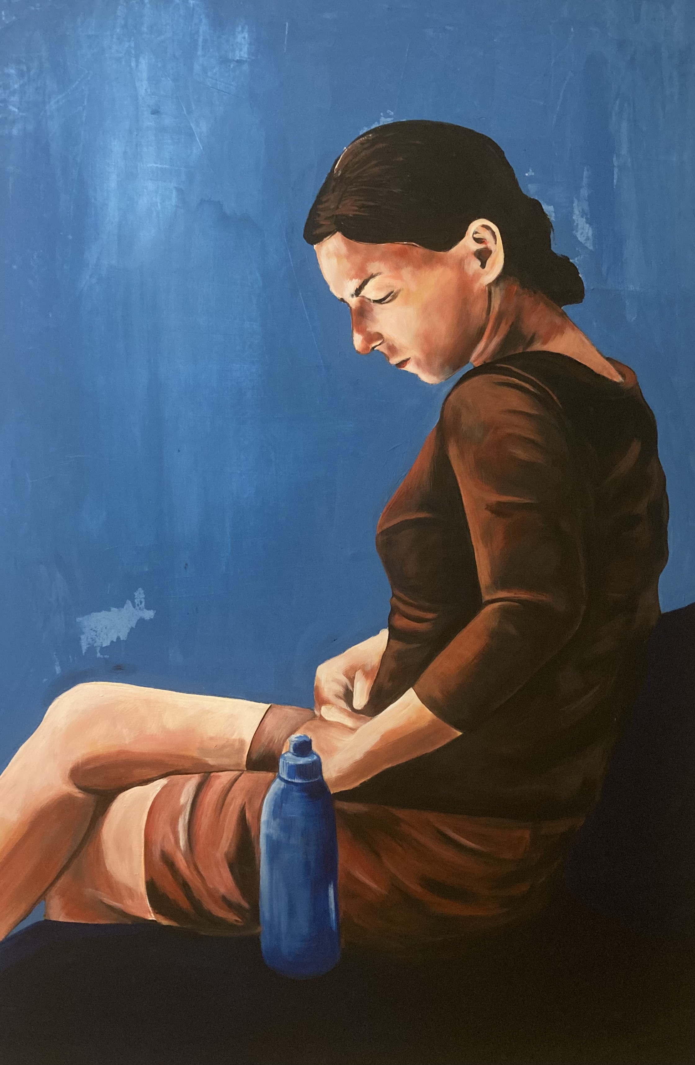 Woman looking down against a blue background.