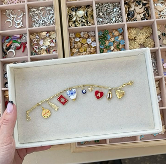 Charme-Armband mit verschiedenen Anhängern in einer Schachtel.