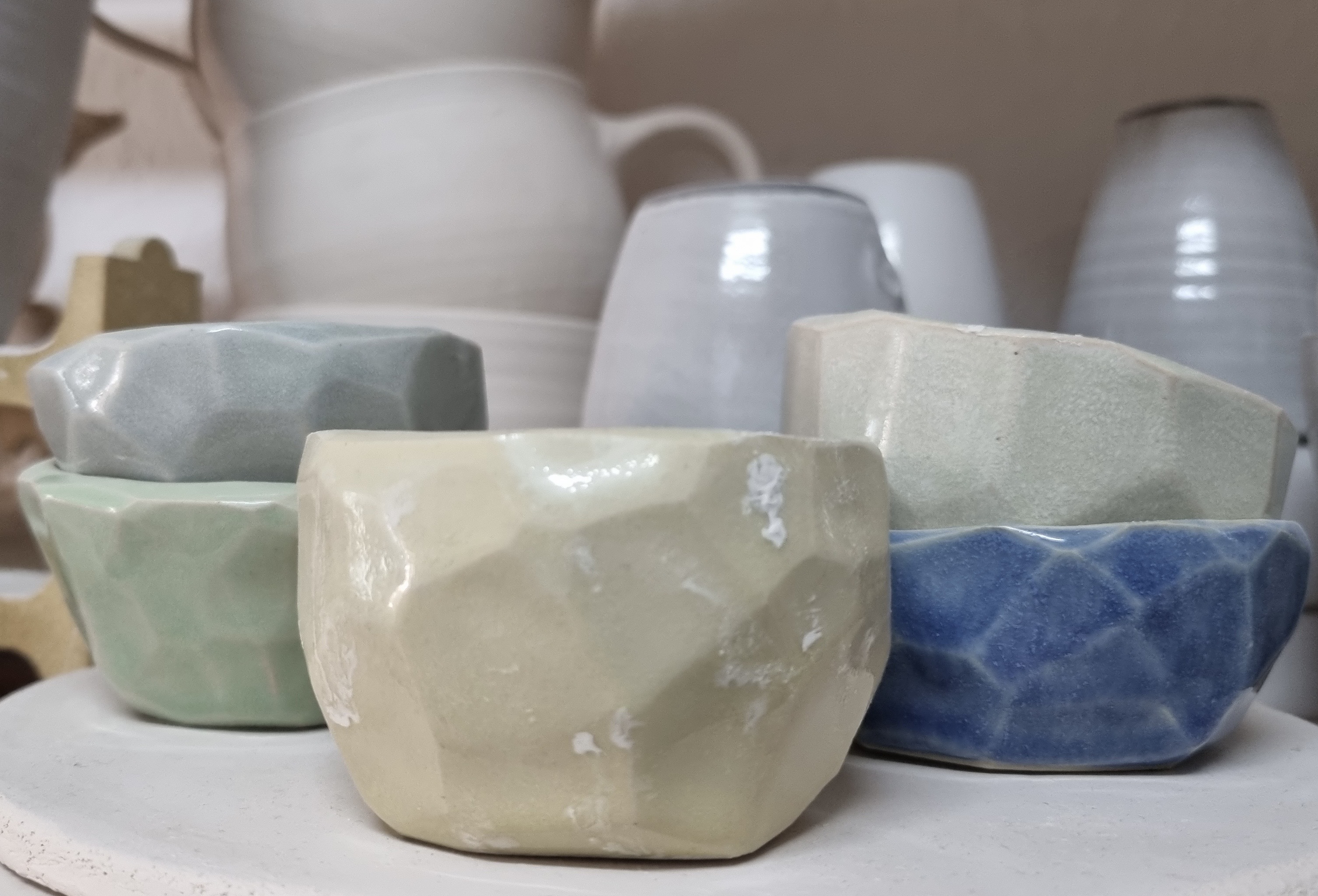 Colorful ceramic bowls stacked on a shelf.