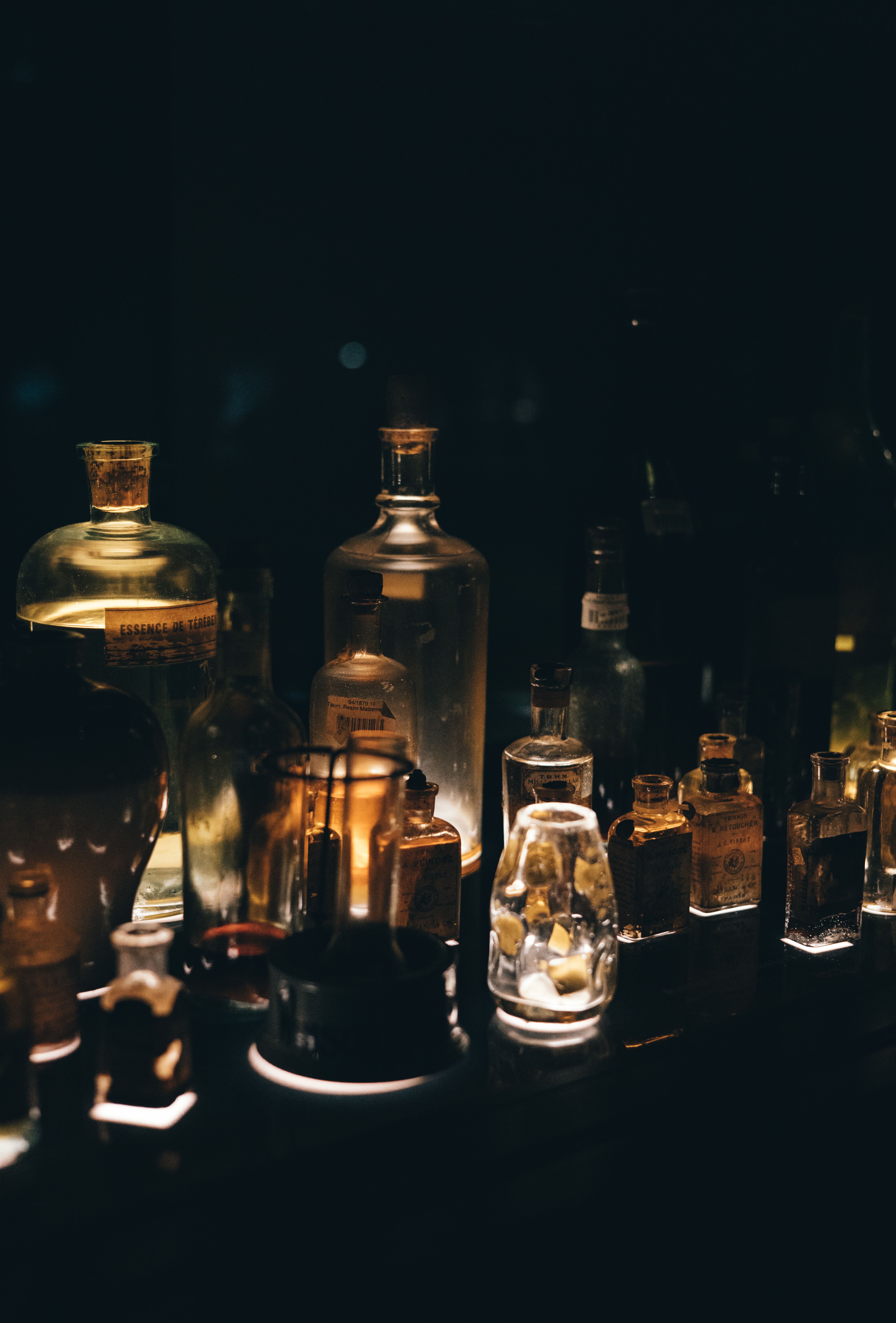 Various antique bottles on a dimly lit shelf.