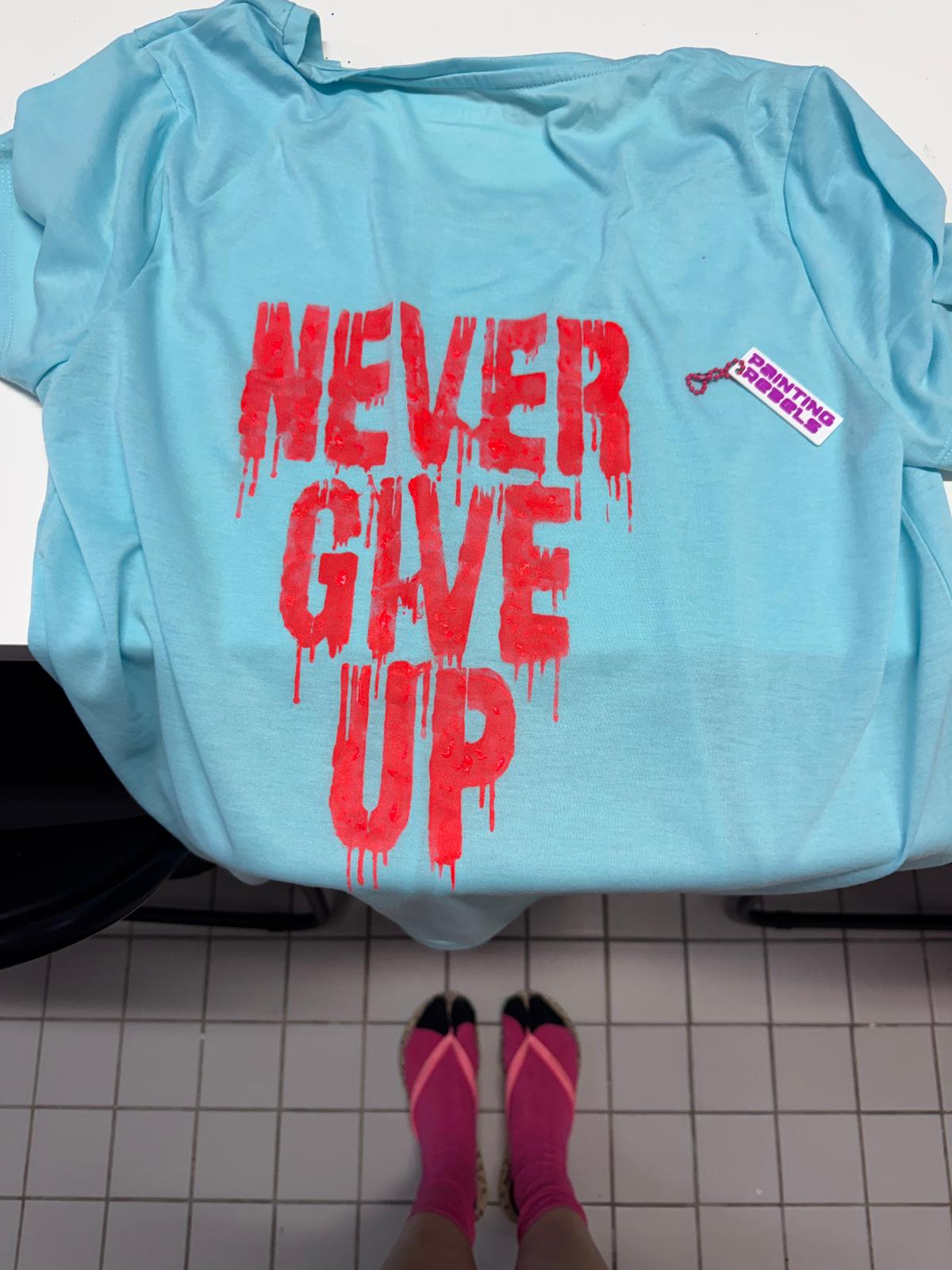 Blaues Shirt mit rotem Text 'Never Give Up'.