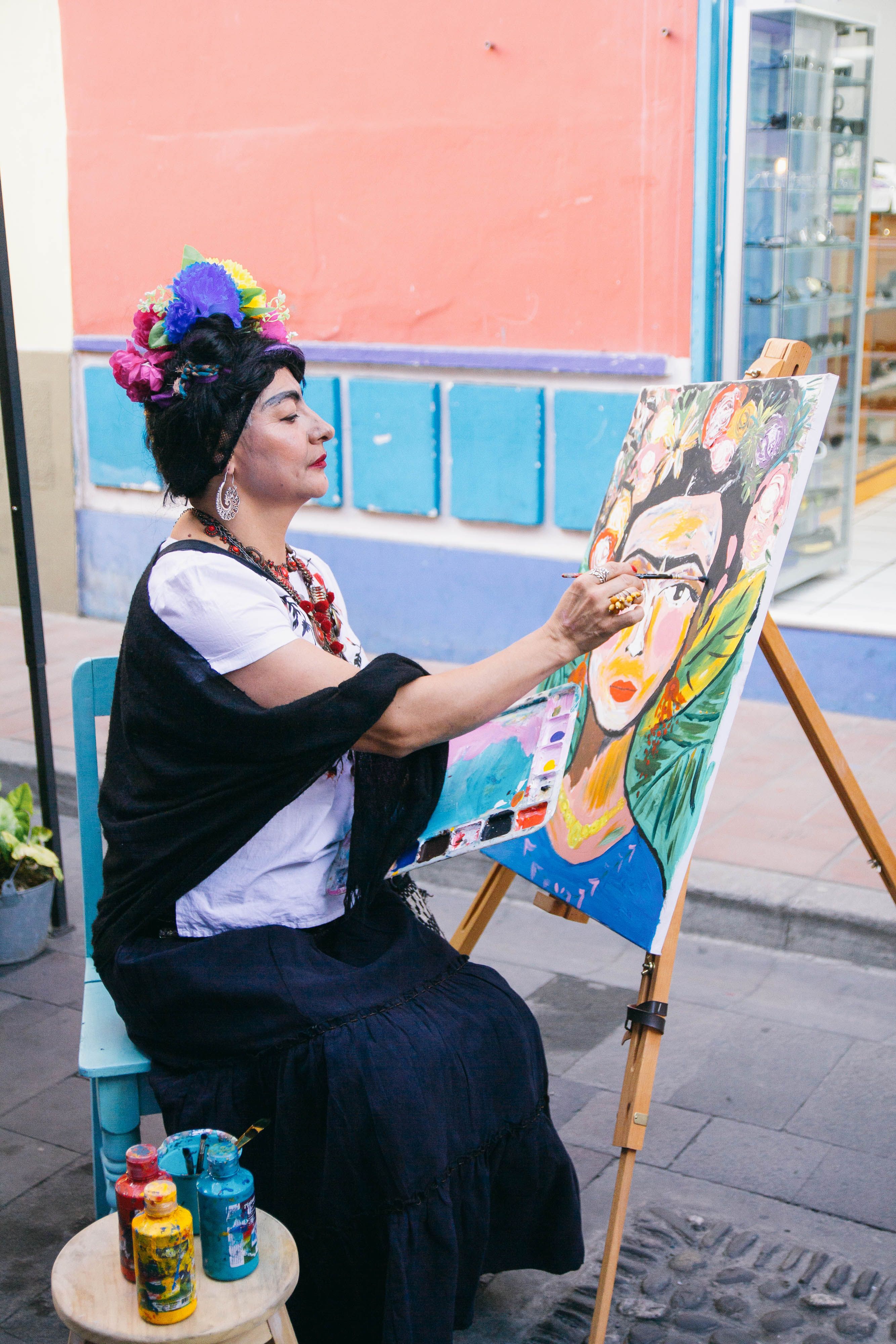 Künstlerin malt Frida-Kahlo-Porträt im Freien.