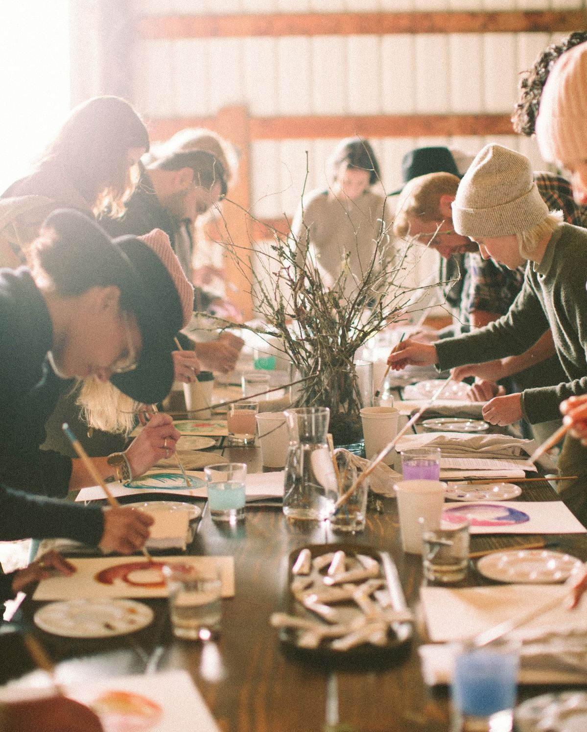 People painting around a table, indoor setting.