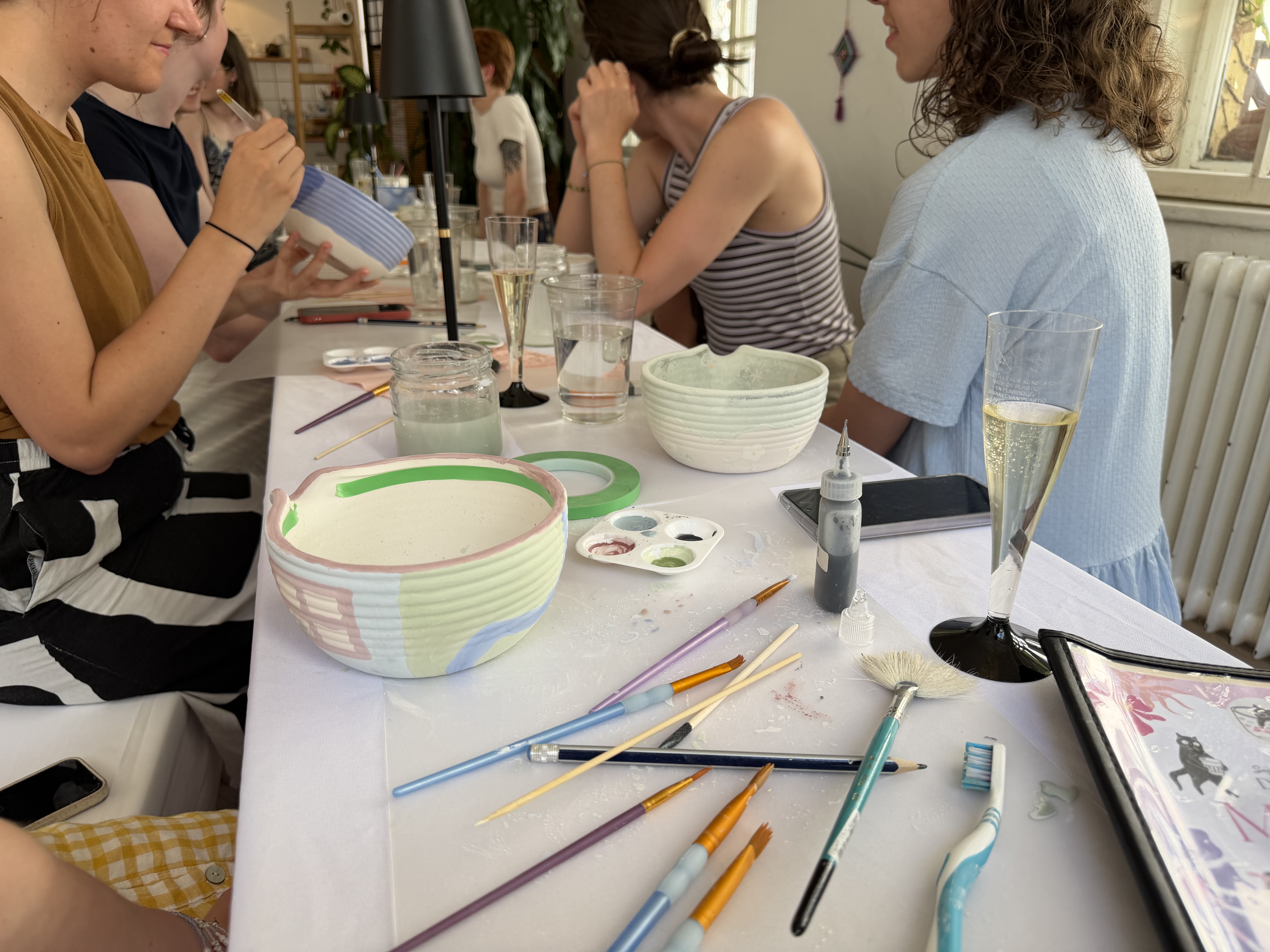 People painting ceramic bowls at a table.