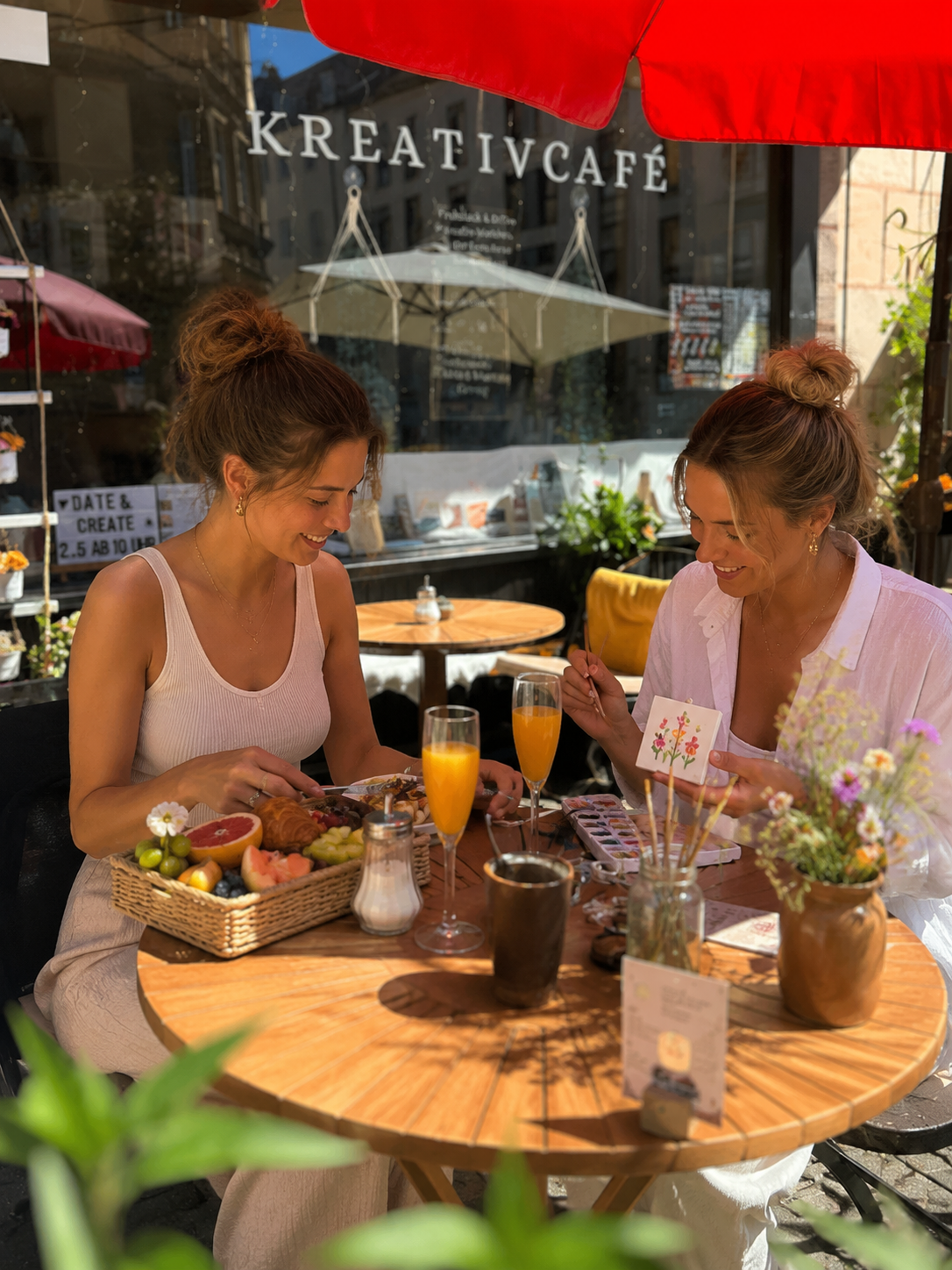 Two women enjoying brunch in outdoor cafe.