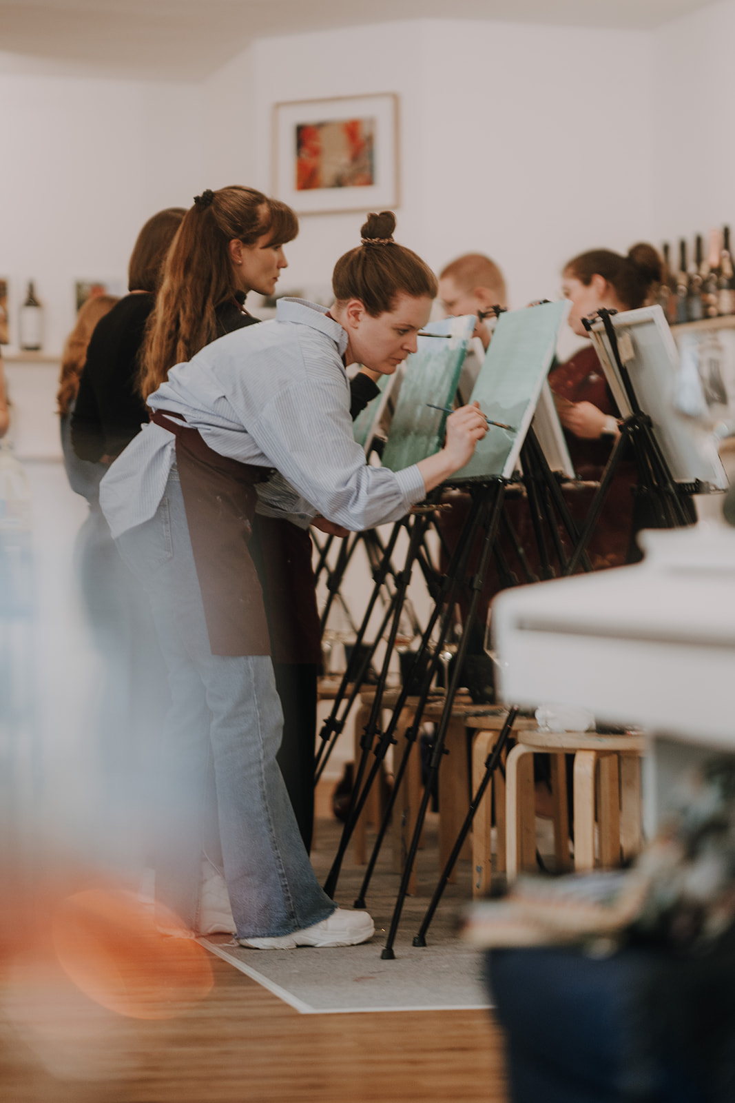 People painting on canvases in a studio.