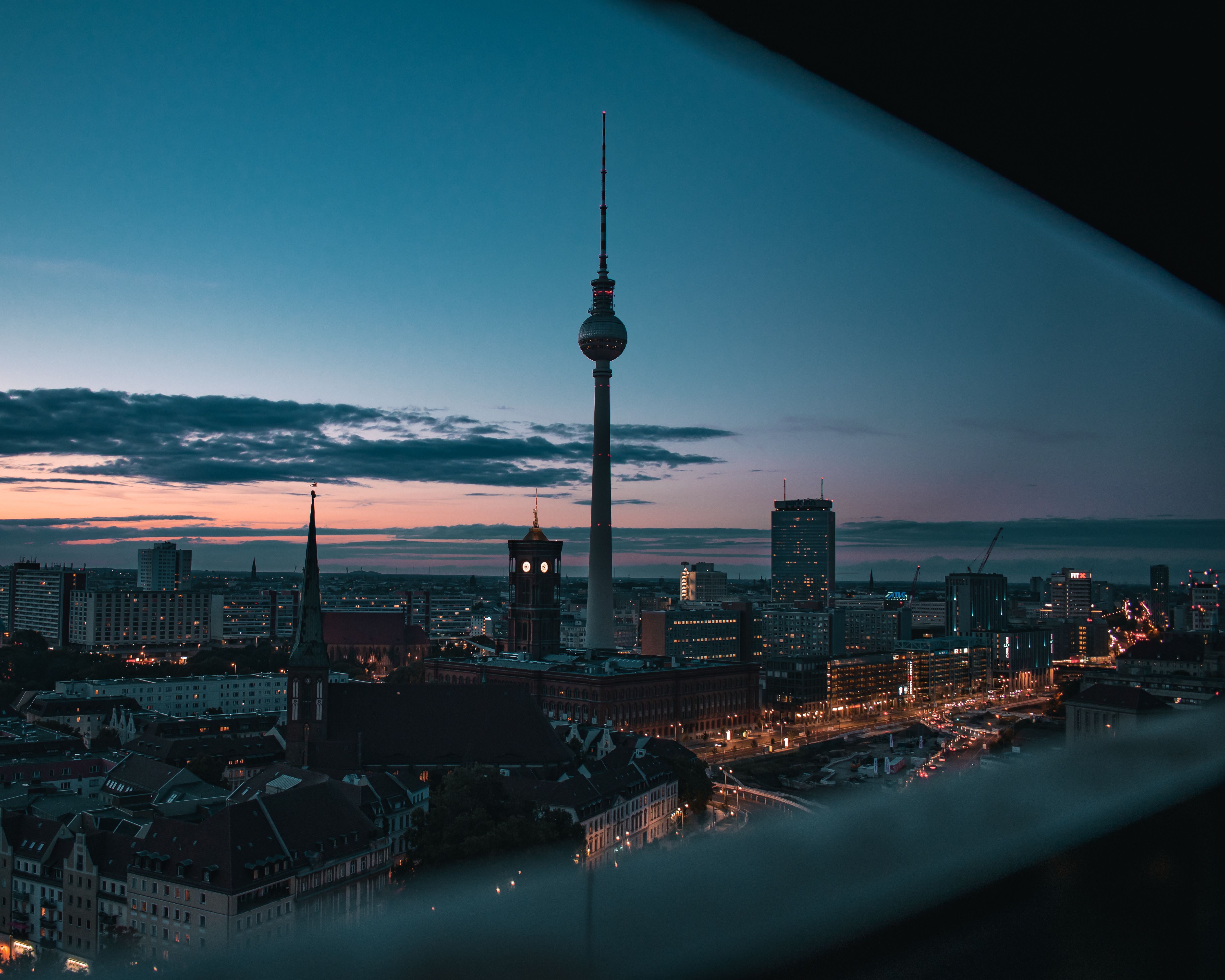 Fernsehturm steht bei Dämmerung in der Stadt.