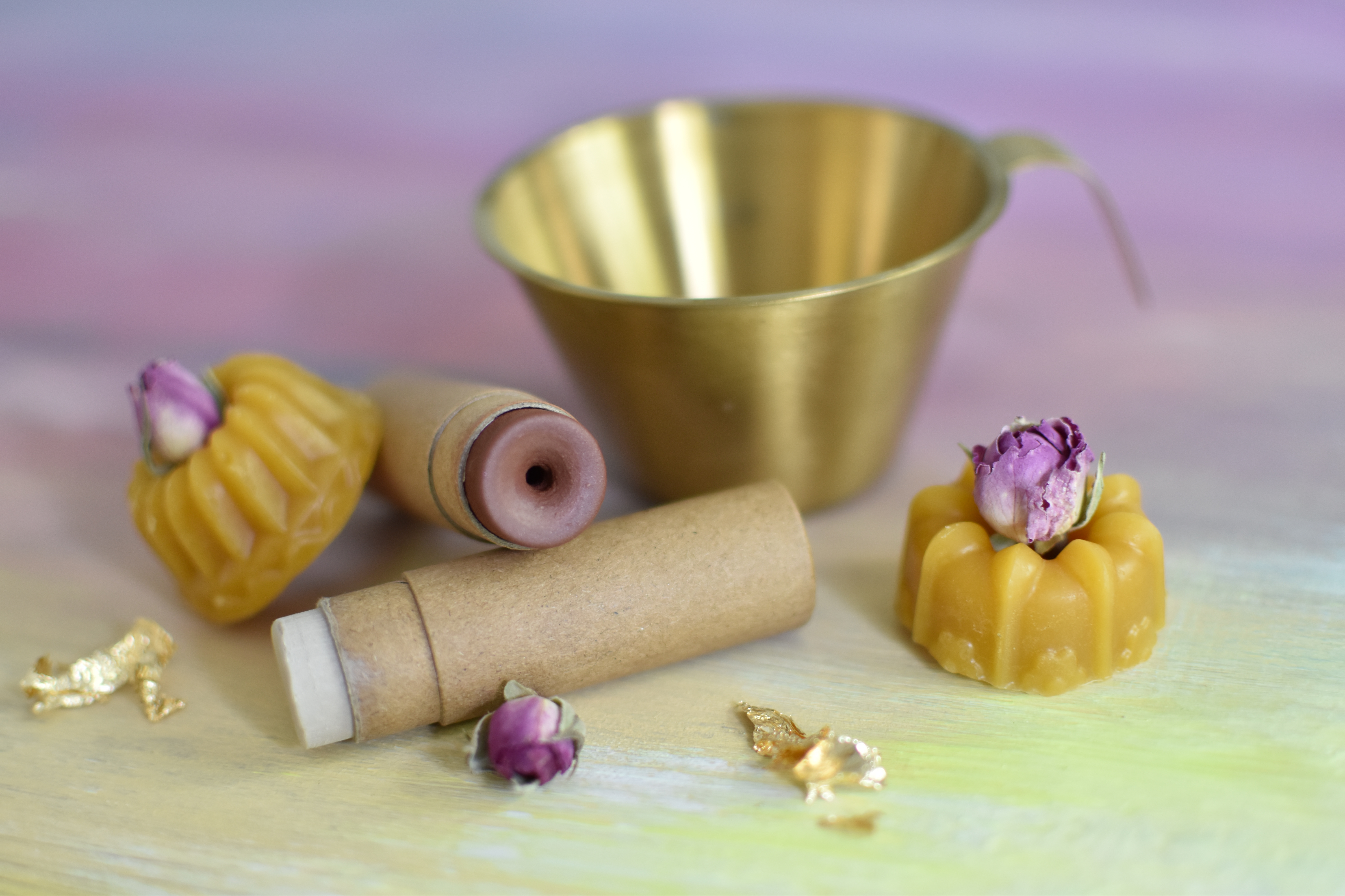 Wachskerzen und Behälter auf pastellfarbenem Hintergrund arrangiert.