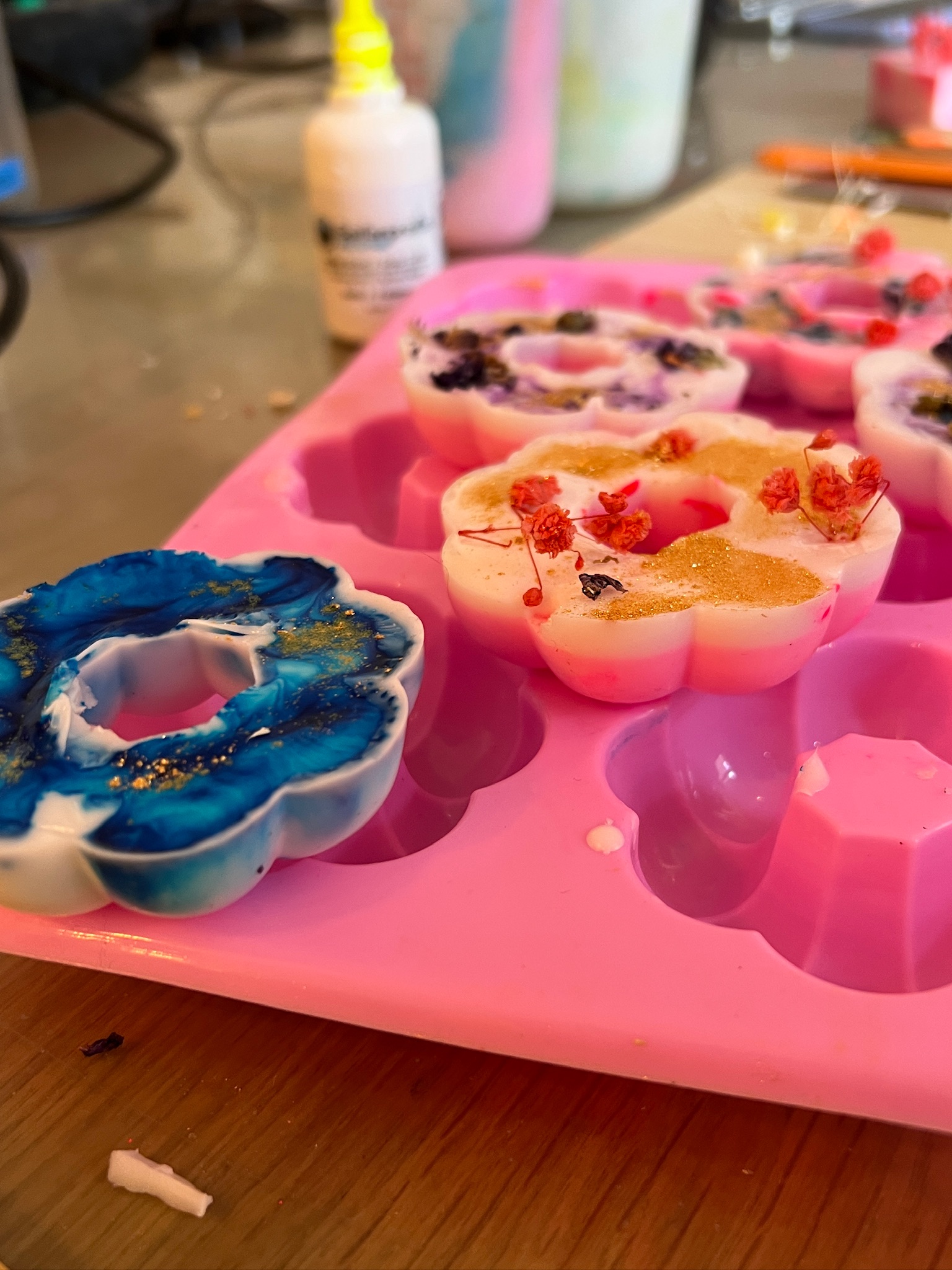Colorful wax melts in flower-shaped mold.