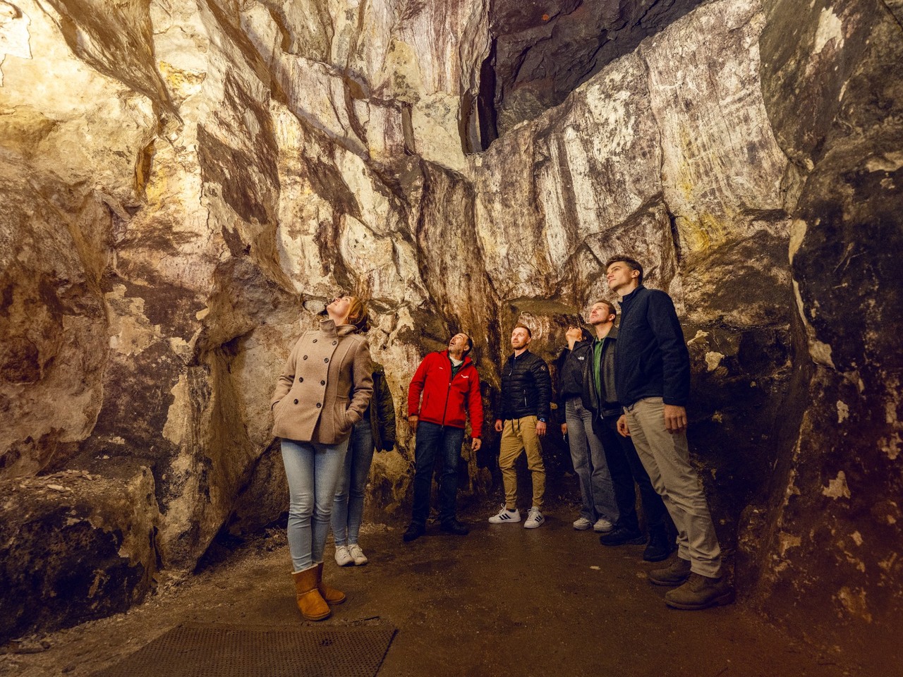 Fünf Personen erkunden eine Höhle.