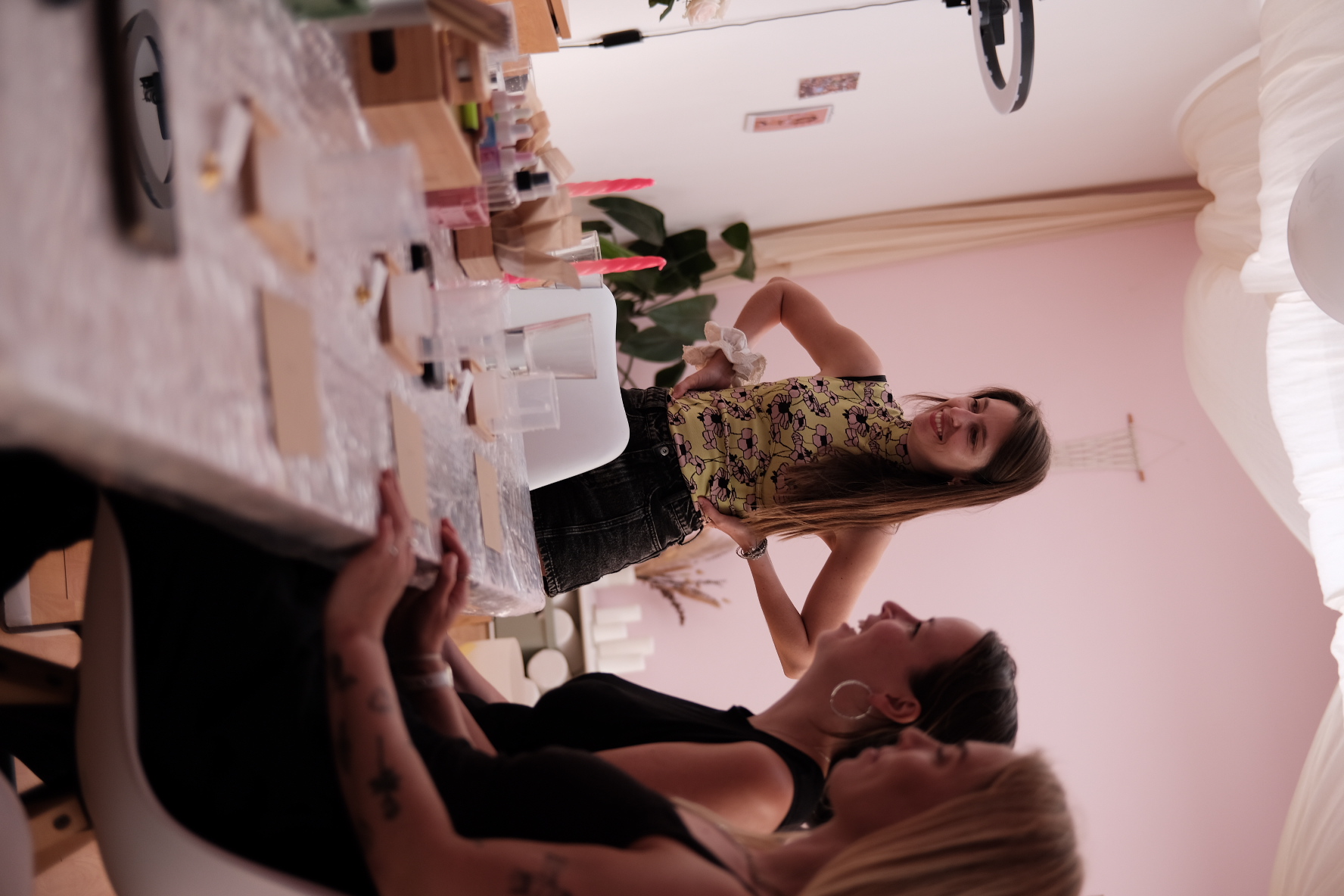 Women smiling, gathered around a table indoors.