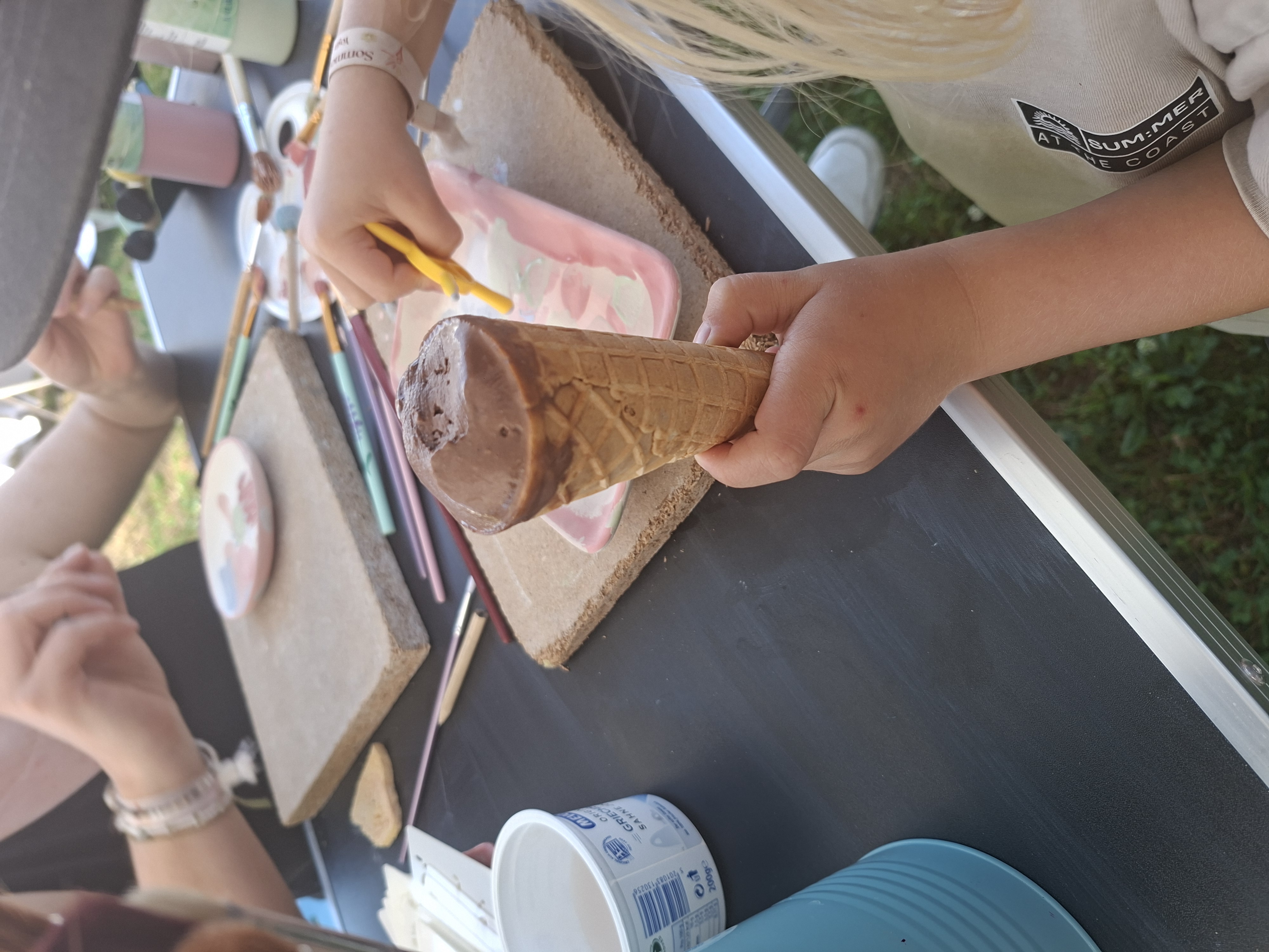 Kind hält Eis an Kunsttisch.