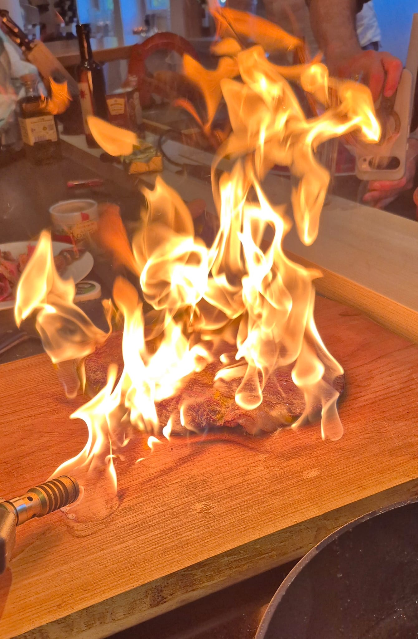 Steak on fire, wooden board background.