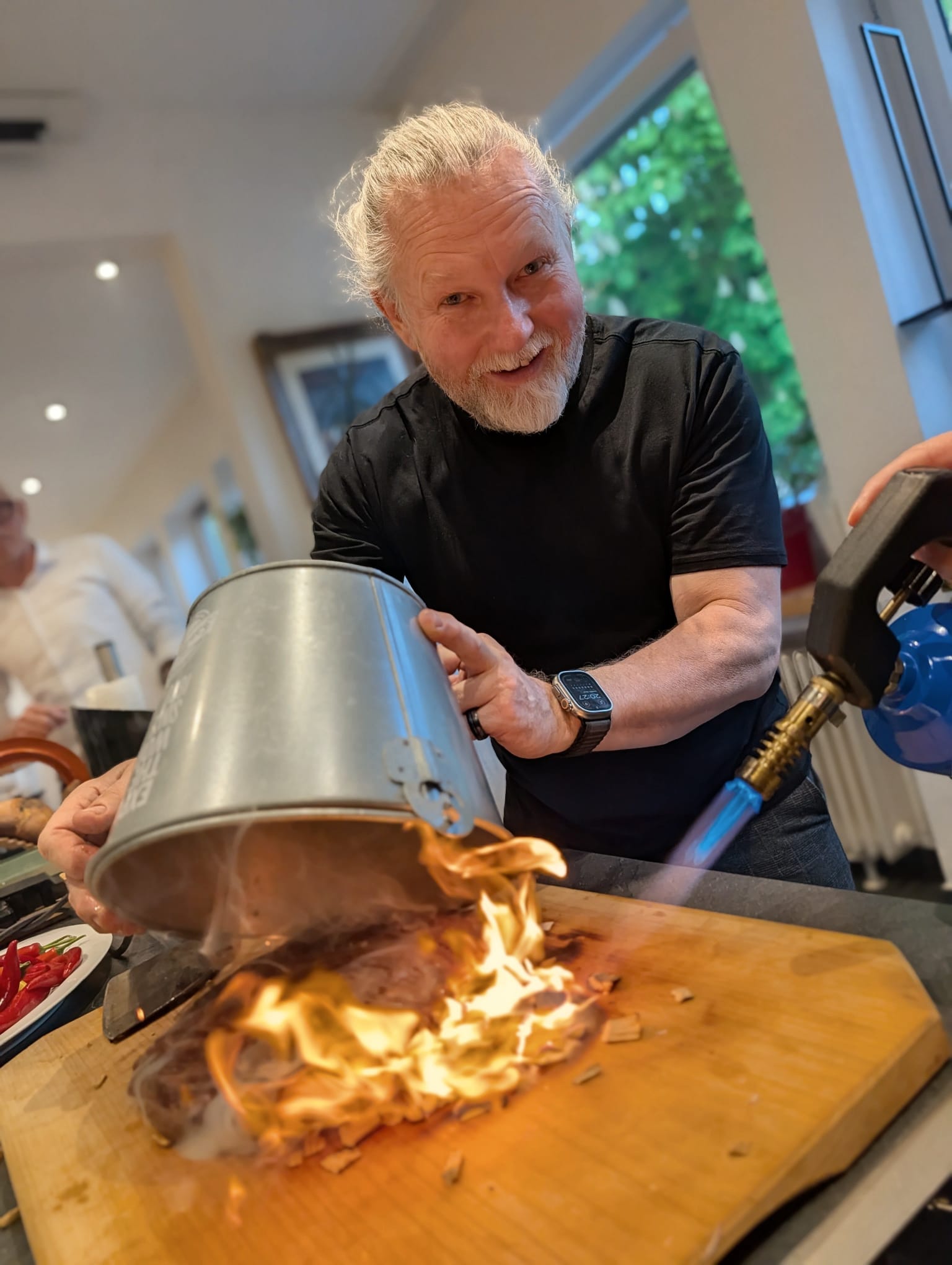 Person torching food on wooden board.