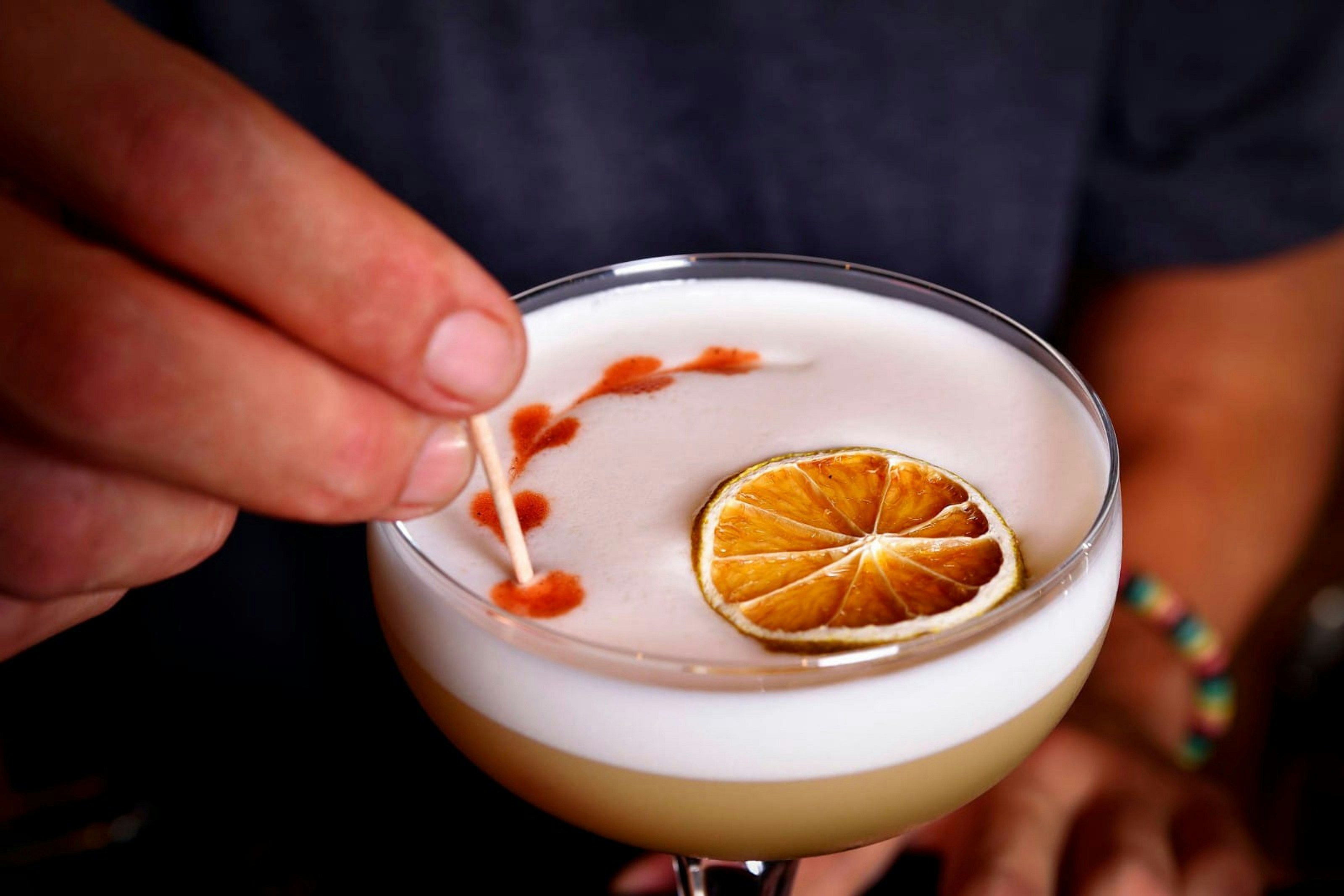 Cocktail mit Zitrusscheibe und Kunst garniert.