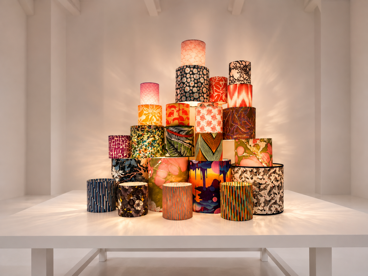 Colorful lampshades stacked in pyramid shape indoors.