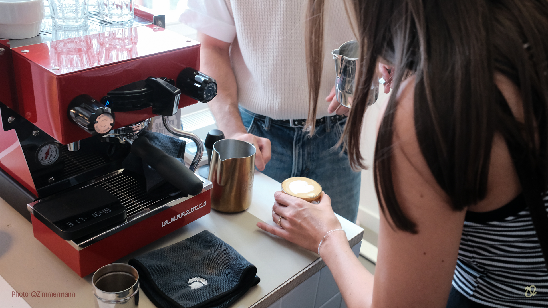 People making coffee at espresso machine.