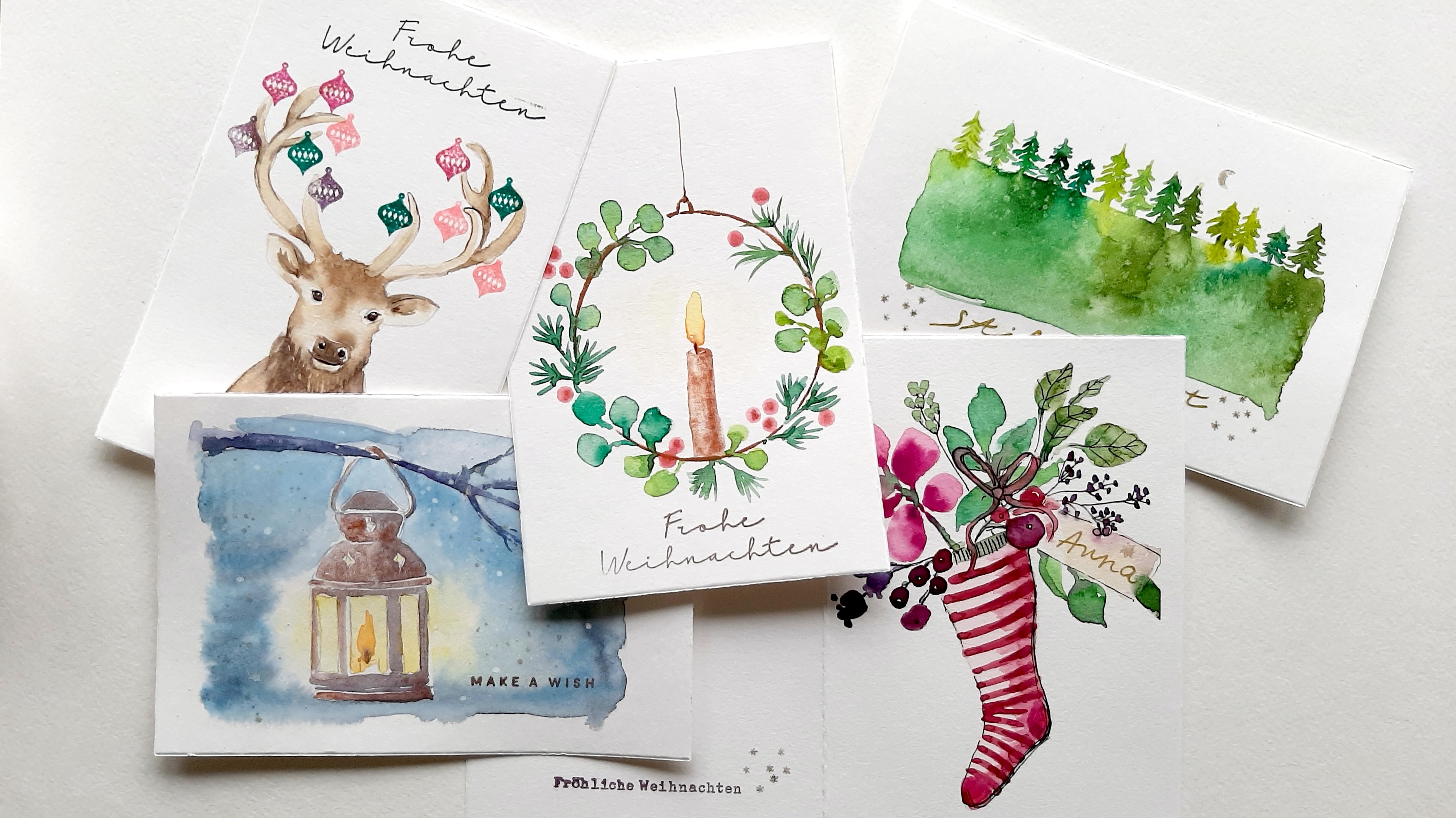 Fünf Weihnachtskarten mit festlichen Designs.