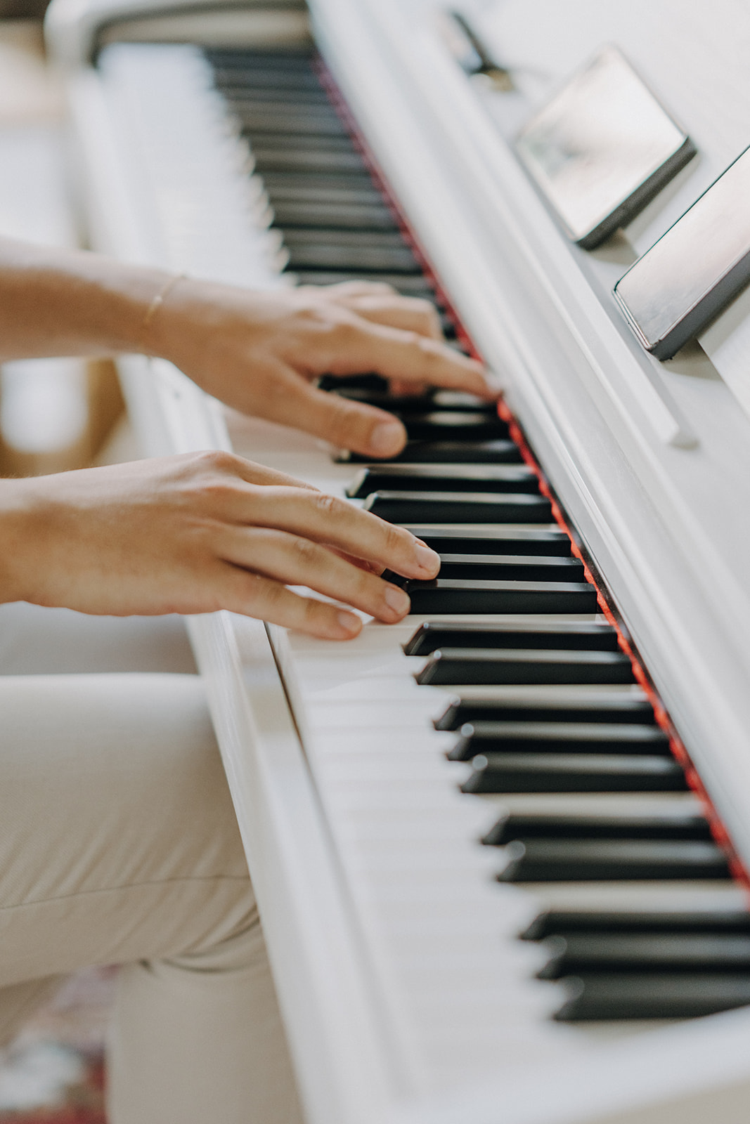 Hands playing piano keys, close-up view.
