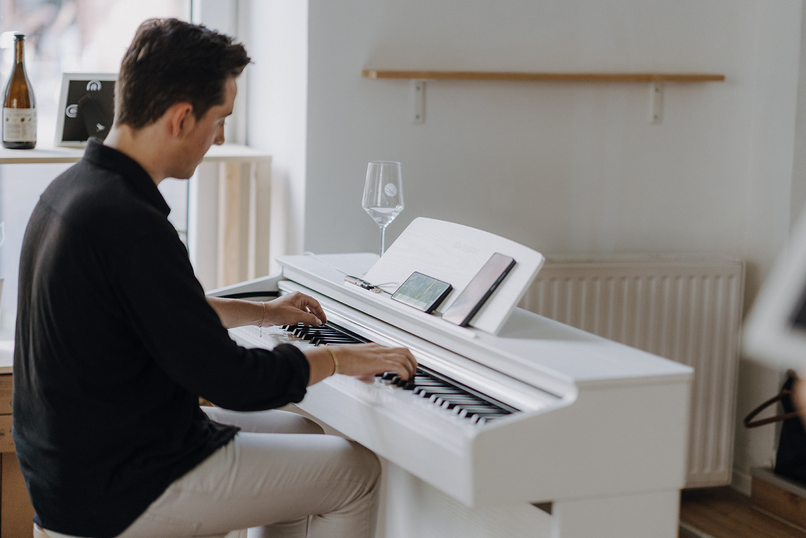 Mann spielt weißes Klavier drinnen.