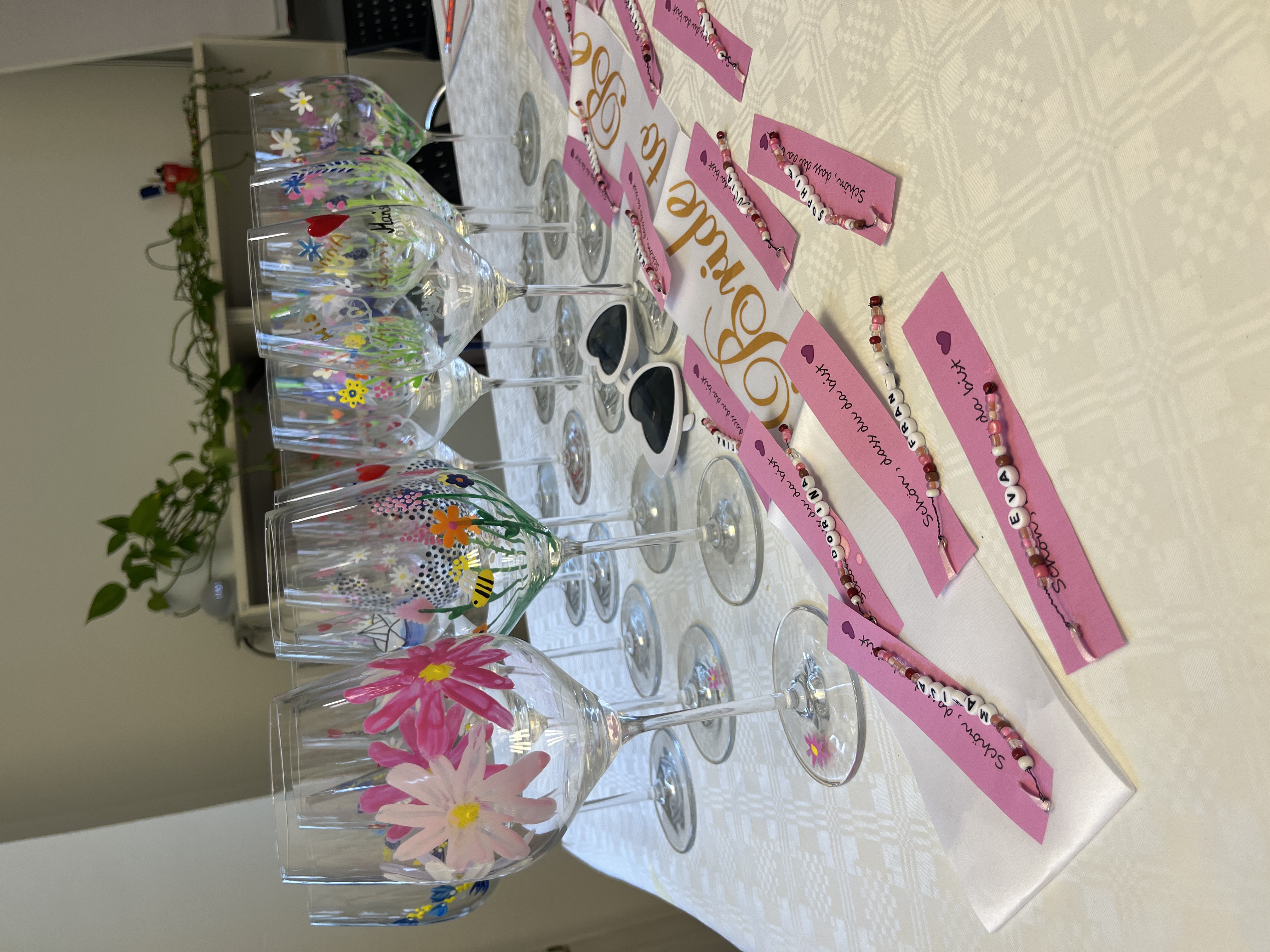 Decorated wine glasses on a white table.