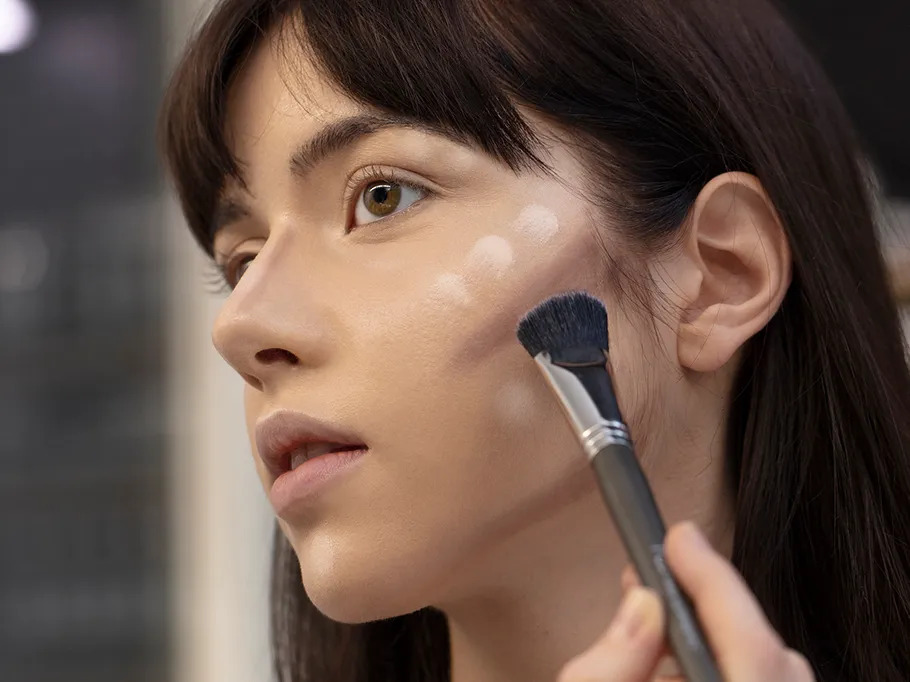 Eine Frau erhält Make-up auf ihr Gesicht im Studio.