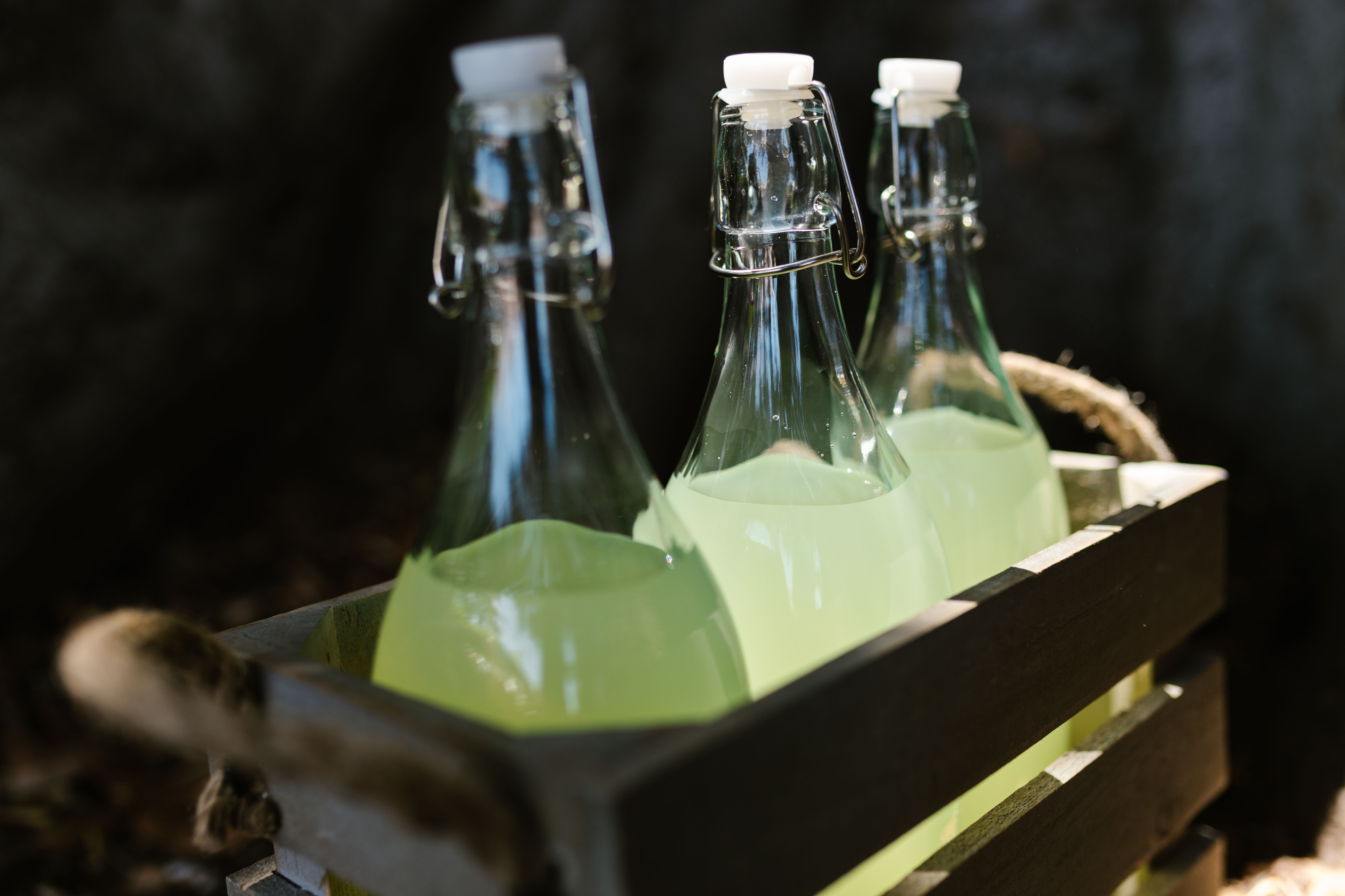 Three glass bottles in a wooden crate.