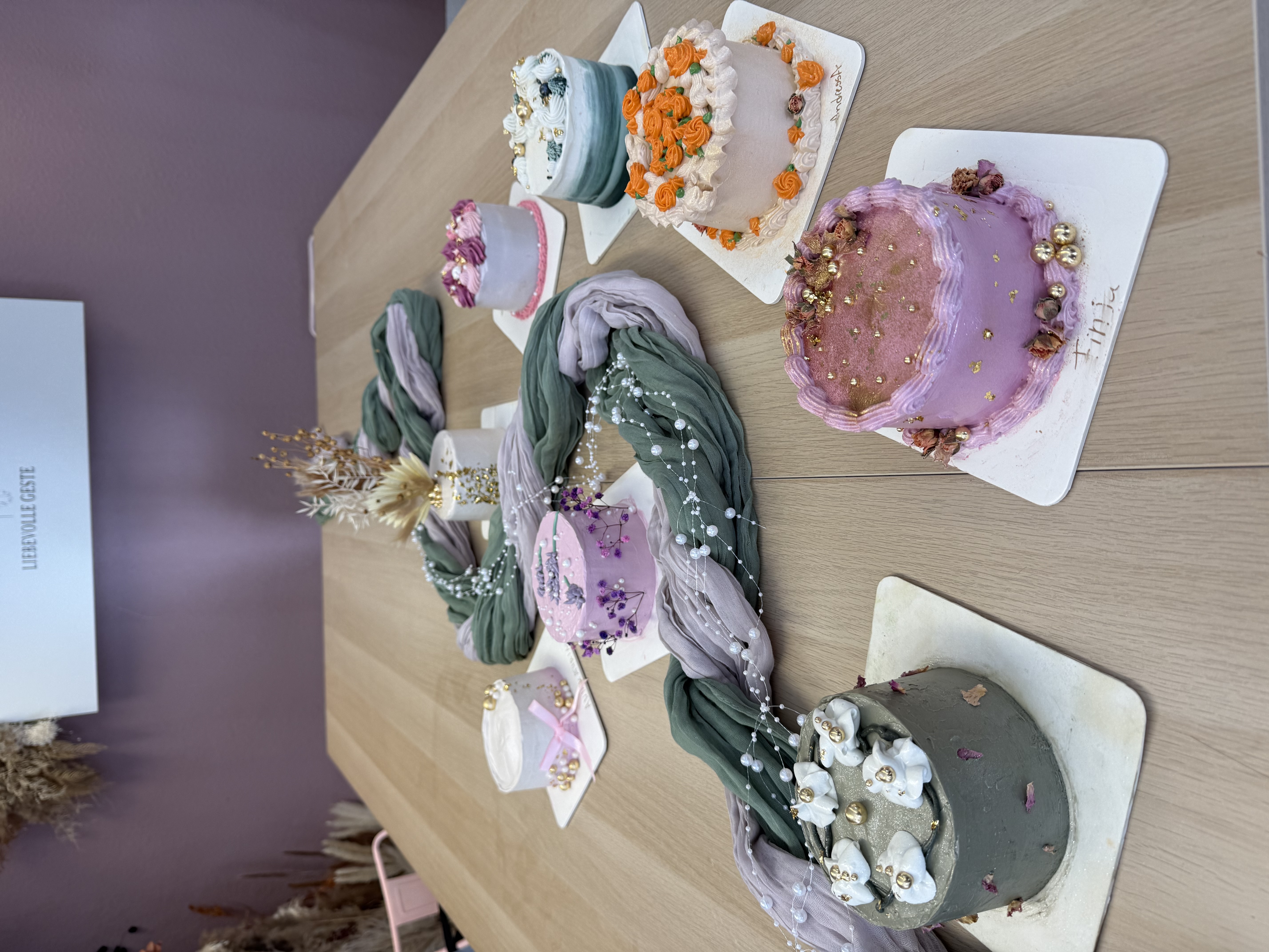 Mini cakes on table, decorative floral theme.
