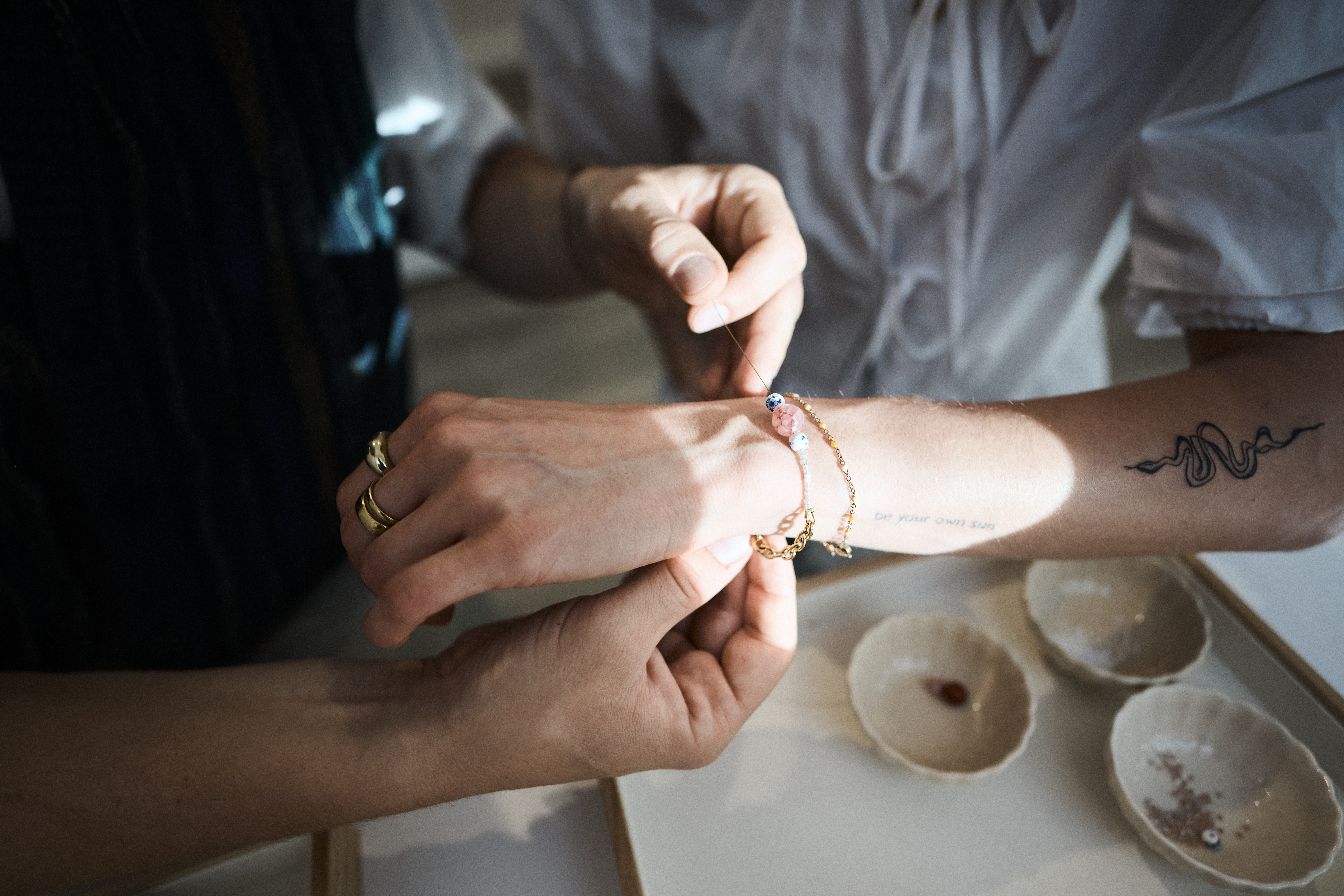 Hände legen Armband an Hand an.
