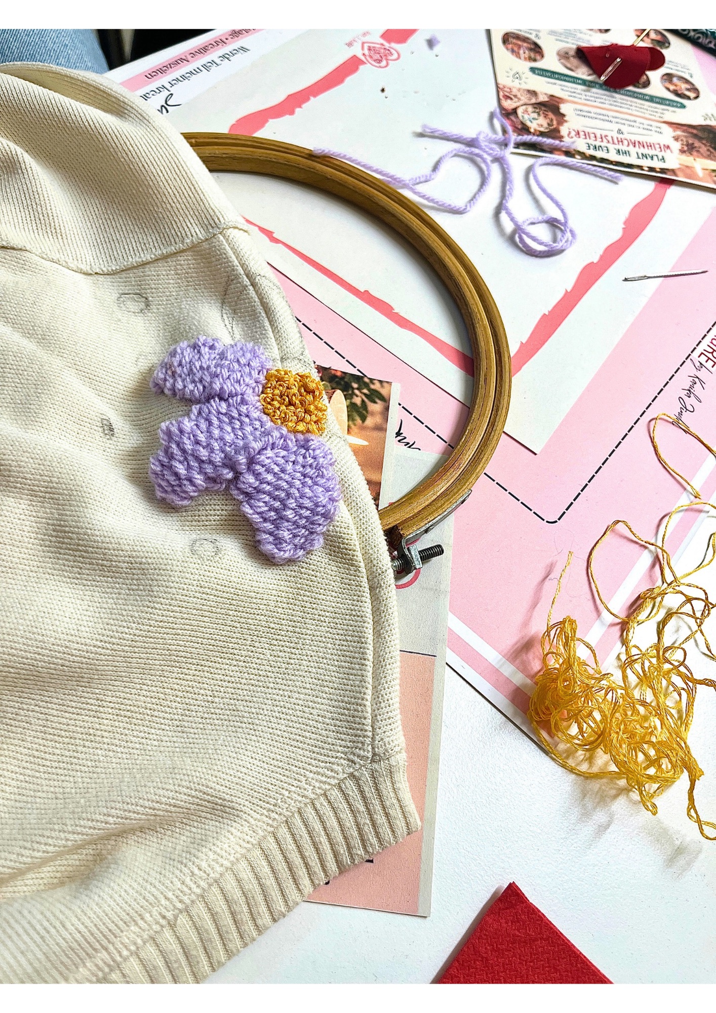 Fabric with embroidered flower, crafting tools.