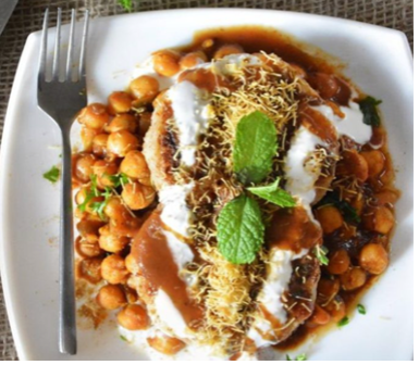 Plate with chickpeas, yoghurt, sauce and spices.