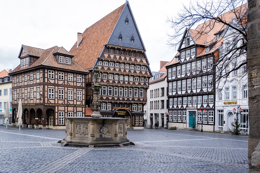 Alter Brunnen in einer Stadt mit Fachwerkhäusern.