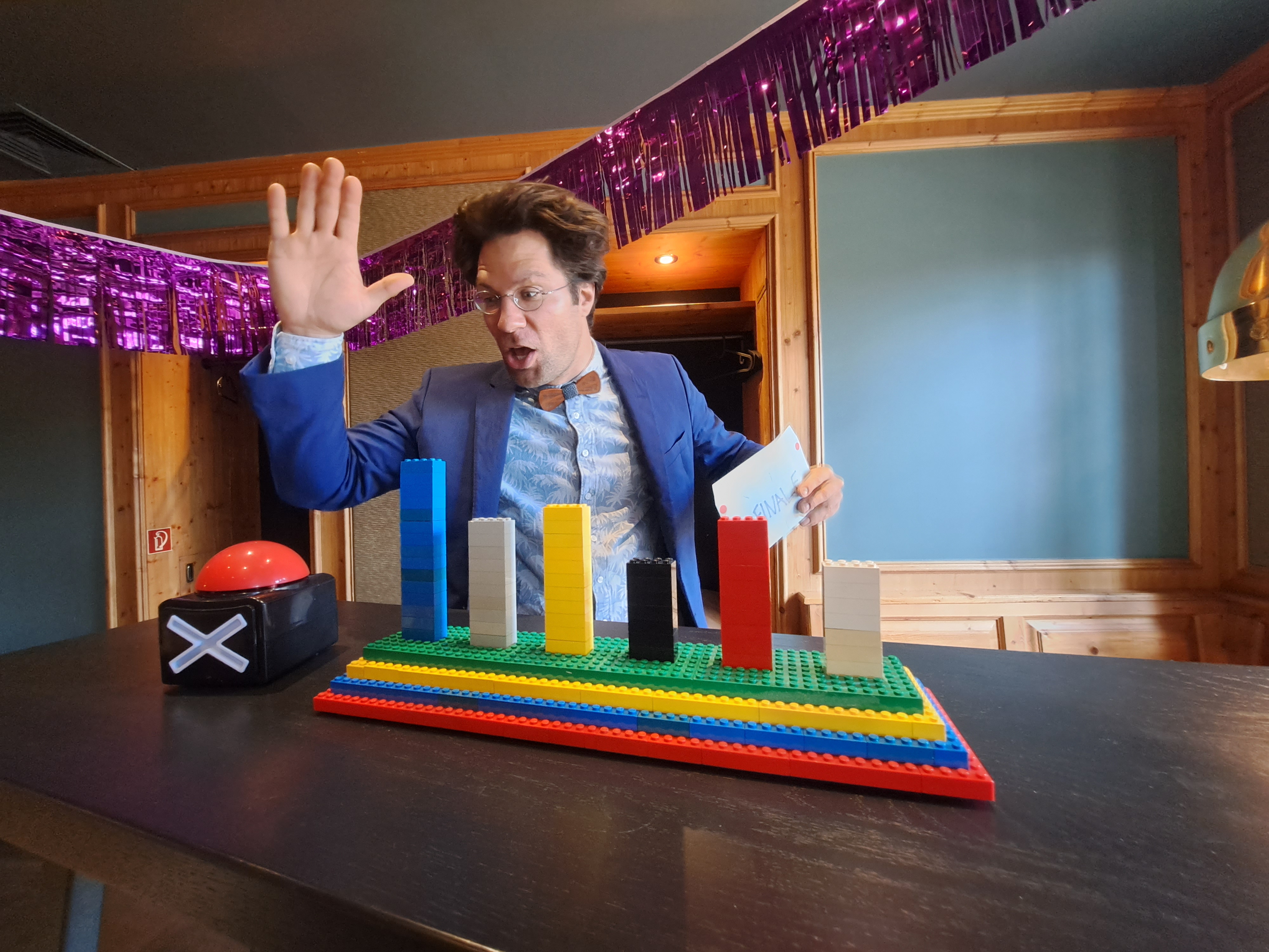 Ein Mann zeigt mit der Hand auf bunte Bauklötze.