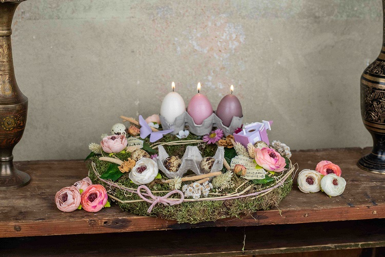 Decorated table with easter eggs, candles and flower arrangements