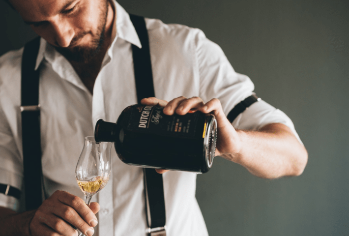 Ein Mann gießt einen Drink in ein Glas.