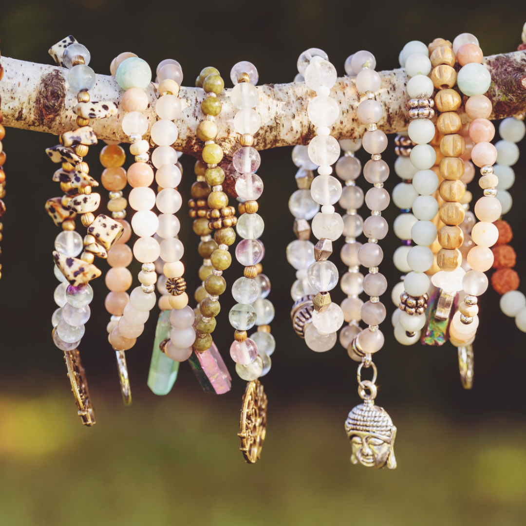 Necklaces of pearls hang from a branch in natural light.