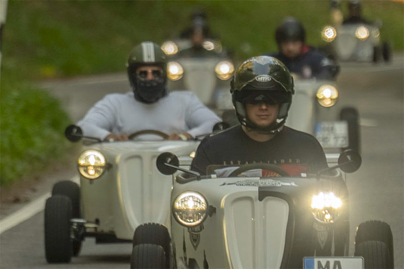 Kleine Autos fahren auf einer kurvigen Landstraße.