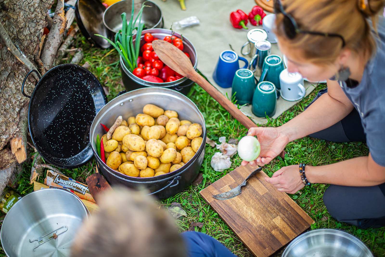 Potatoes are prepared while someone is peeling an egg.