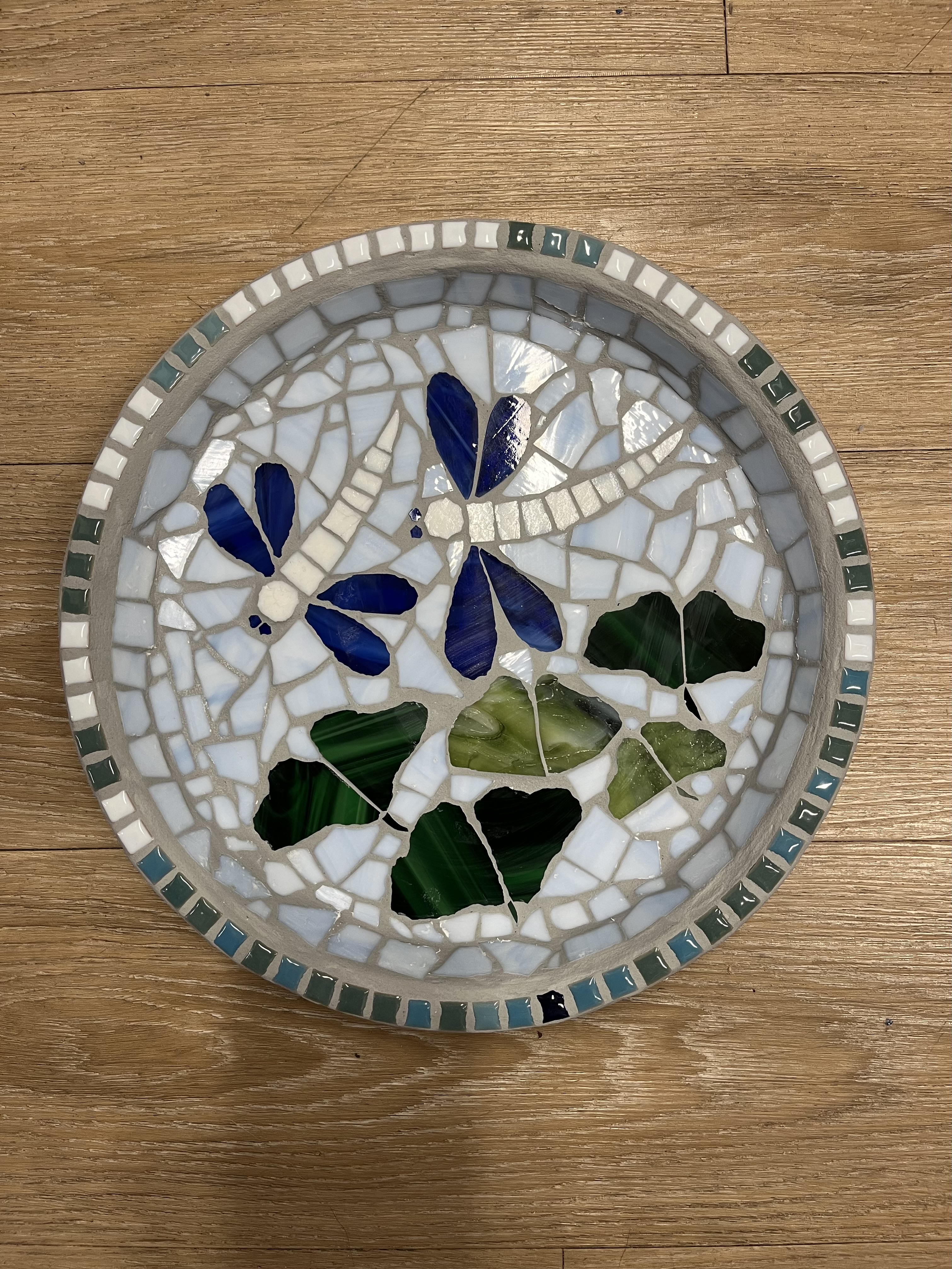 Round mosaic plate with blue butterflies and green leaves
