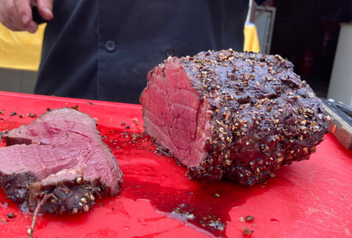 Piece of beef on red cutting board, freshly sliced.