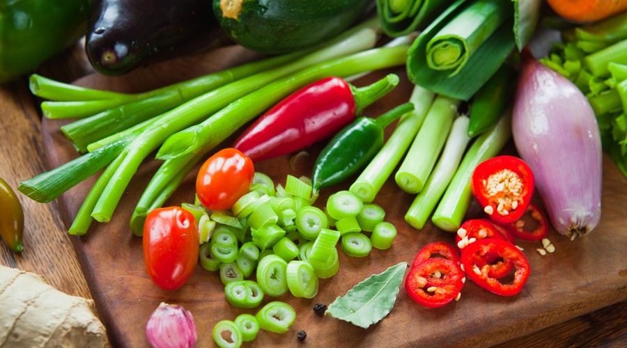 Vegetables lie on a wooden board, arranged in a fresh and colorful way.