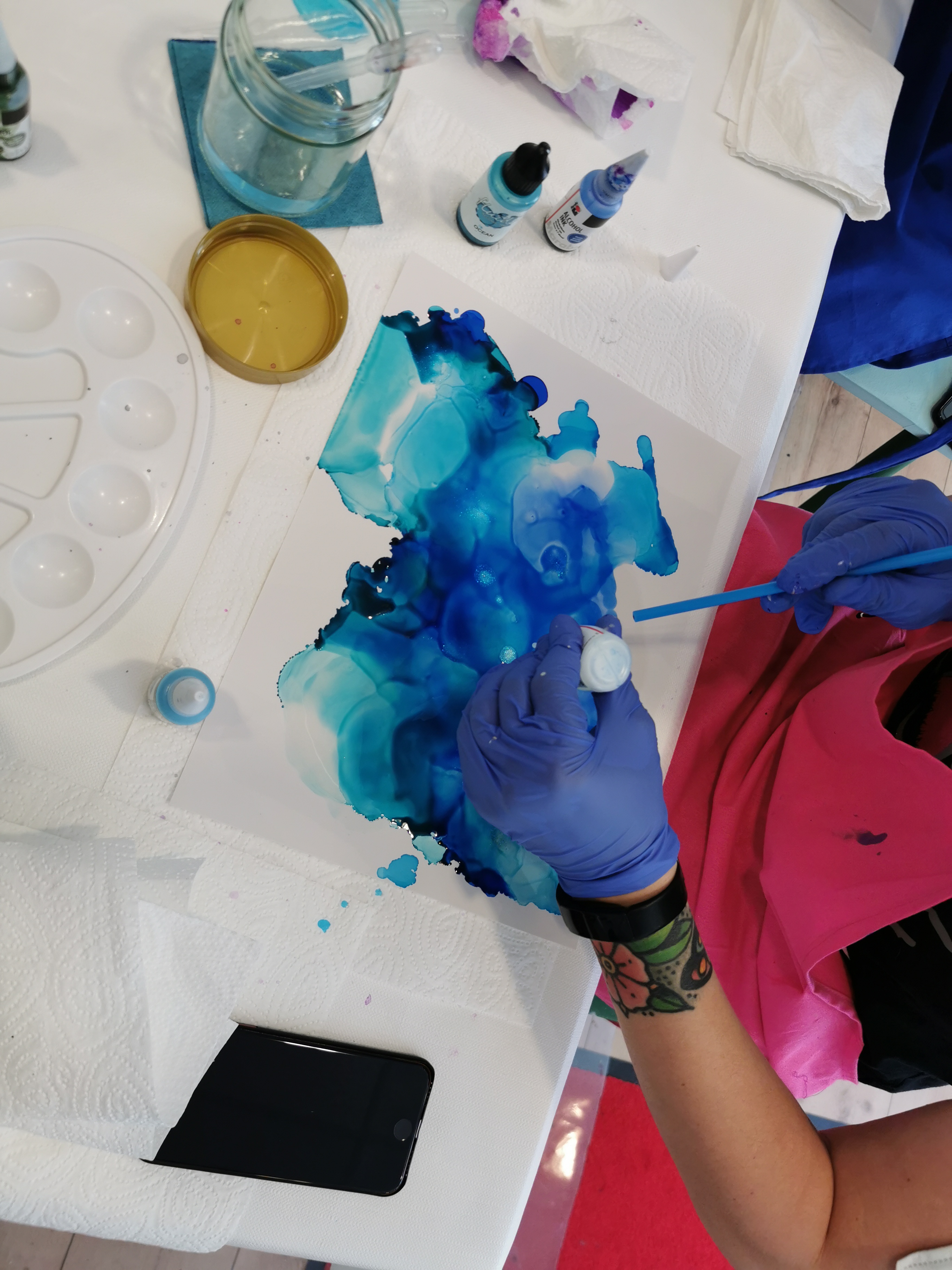 Farben werden auf einem Blatt Papier in Blau aufgetragen.