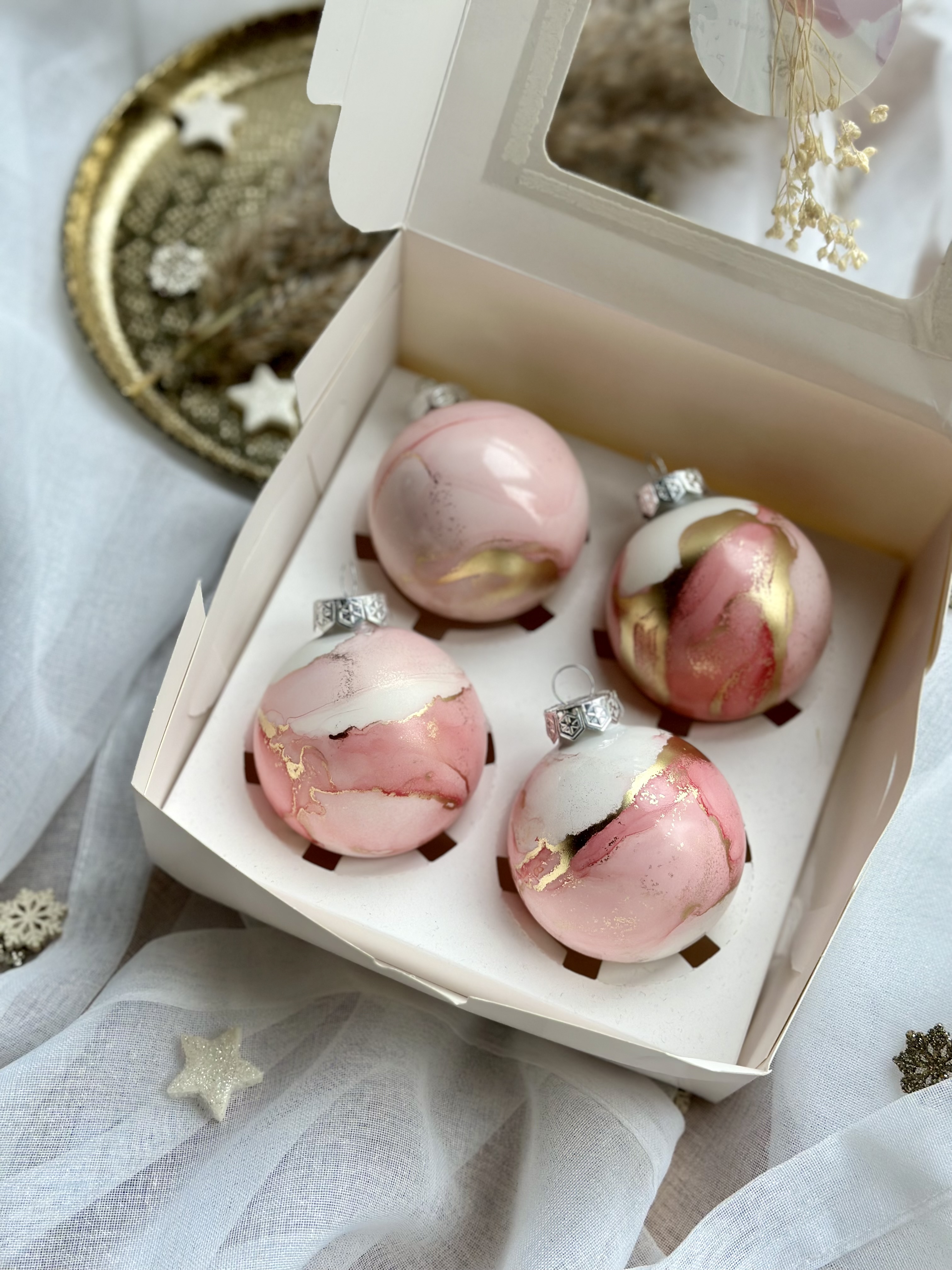 Colourful Christmas balls lie in a decorative box.